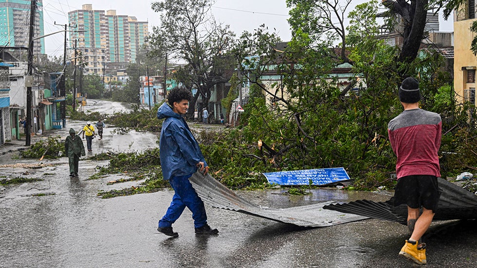 SANTIAGO DE CUBA, CUBA: Residents recover part of the roof of their damaged houses on Wednesday, October 29, 2025, after Hurricane Melissa struck a neighborhood in Santiago de Cuba. (Photo by YAMIL LAGE/AFP via Getty Images)