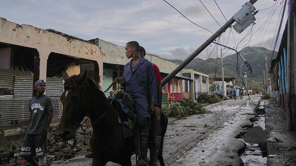 EL COBRE, CUBA: Men ride after the passage of Hurricane Melissa on Wednesday, Oct. 29, 2025. (AP Photo/Ram&oacute;n Espinosa)