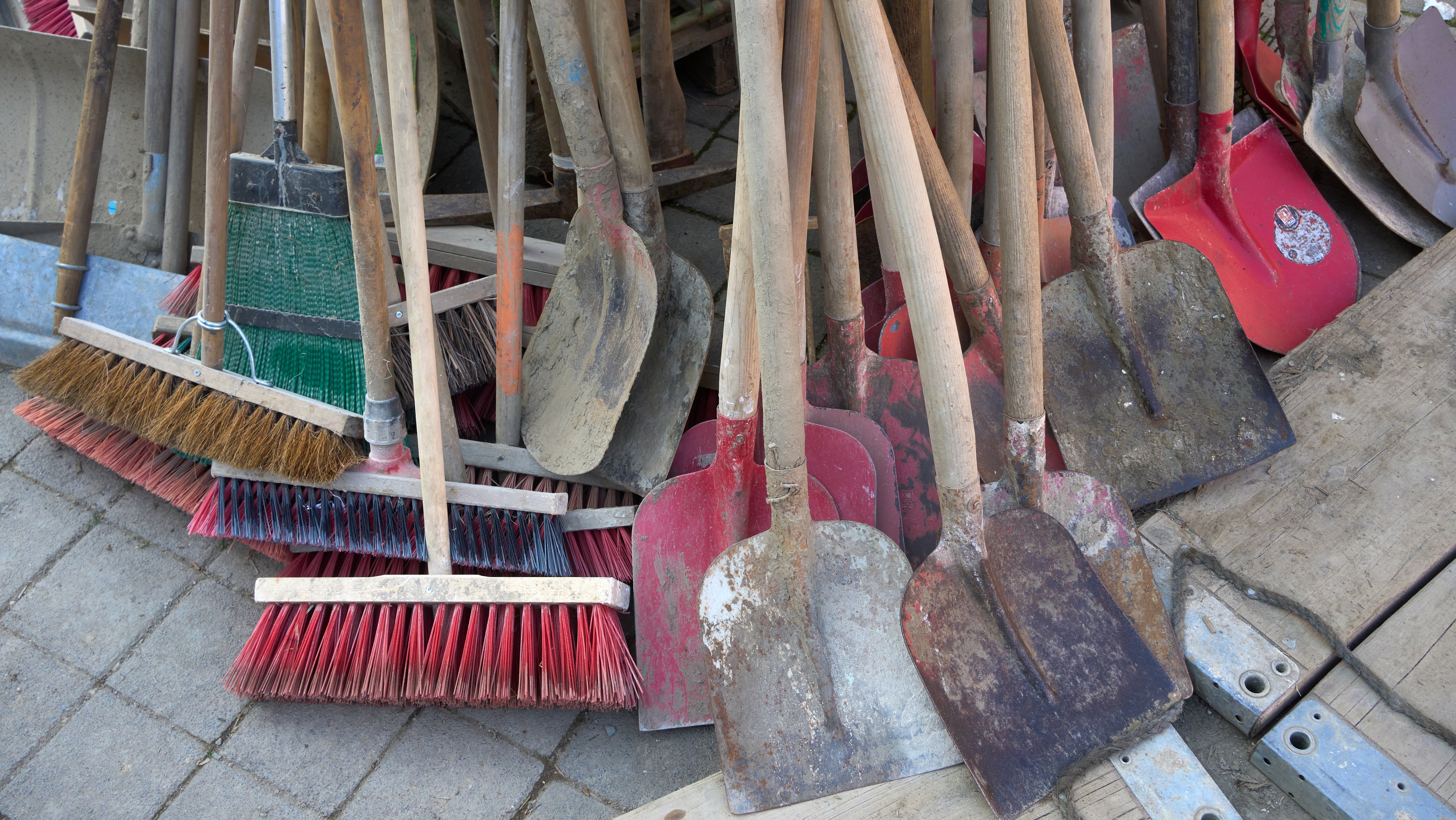 Rheinland-Pfalz, Mayscho&szlig;: Schaufeln und Besen stehen in einer Stra&szlig;e in Mayscho&szlig;. 
