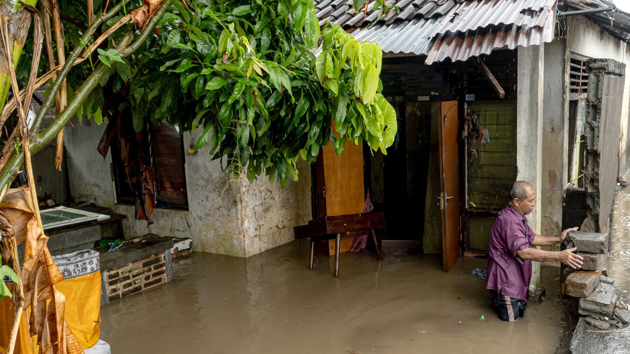 10.09.2025, Indonesien, Bali: Ein Mann steht in der N&auml;he seines &uuml;berschwemmten Hauses, nachdem Denpasar von starken Regenf&auml;llen heimgesucht wurde. (Dicky Bisinglasi/XinHua/dpa)