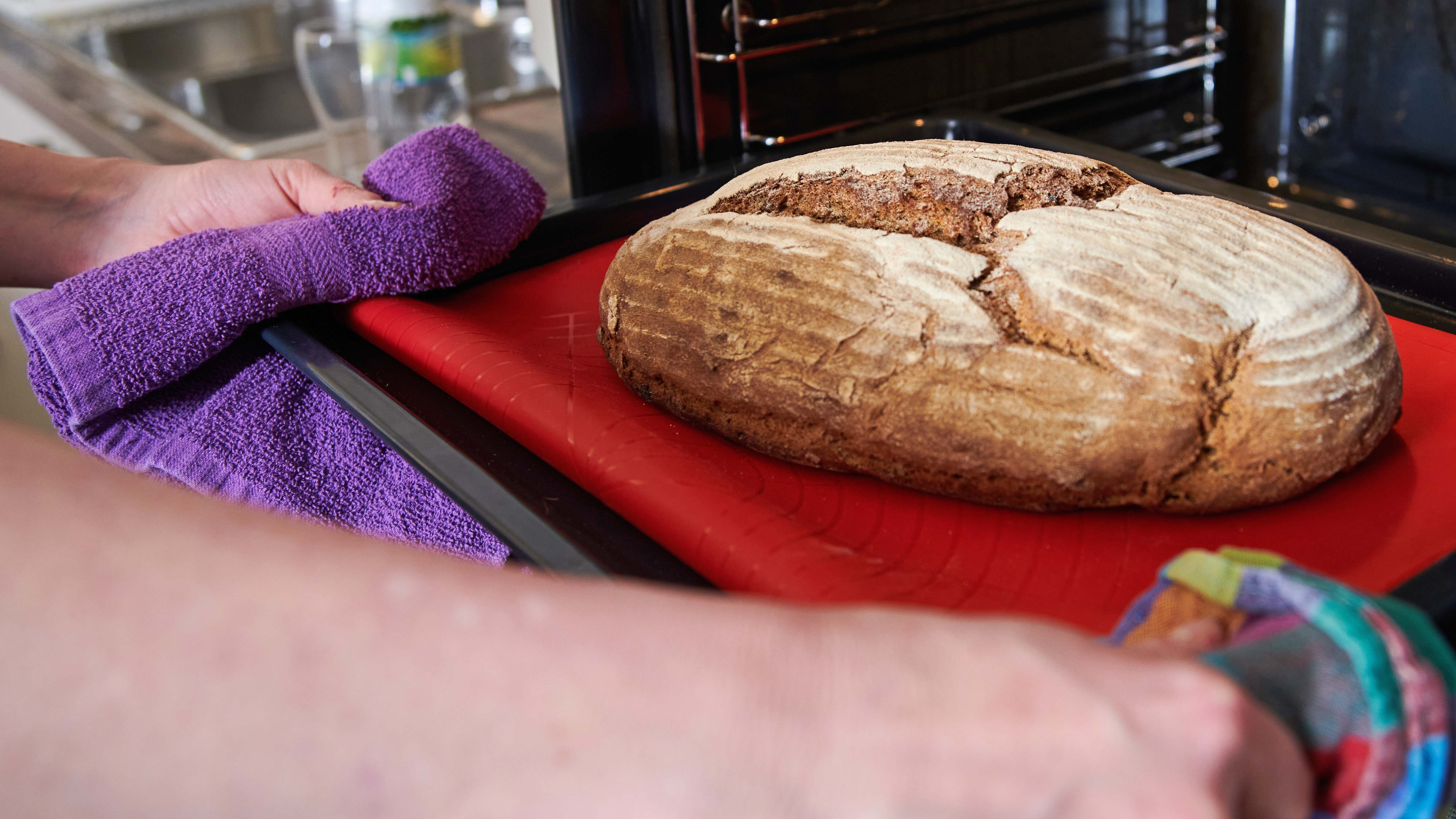 20.01.2021, Berlin: Sonja Scherfer nimmt ein frisch gebackenes Brot aus dem Ofen einer K&cedil;che im Gemeindehauses der evangelischen Dorfkirchengemeinde Britz. Zu Beginn der Pandemie horteten Kunden in den Superm&permil;rkten pl&circ;tzlich Mehl und Hefe. Jetzt wird deutlich, was mit den Unmengen an Mehl passiert ist: Viele Menschen haben das Brotbacken als Hobby f&cedil;r sich entdeckt. Das freut sogar die B&permil;cker. (zu &acute;Zeit und Mehl im &lsaquo;berfluss: Brotbacken als Corona-Trend&ordf;) Foto: Annette Riedl/dpa +++ dpa-Bildfunk +++