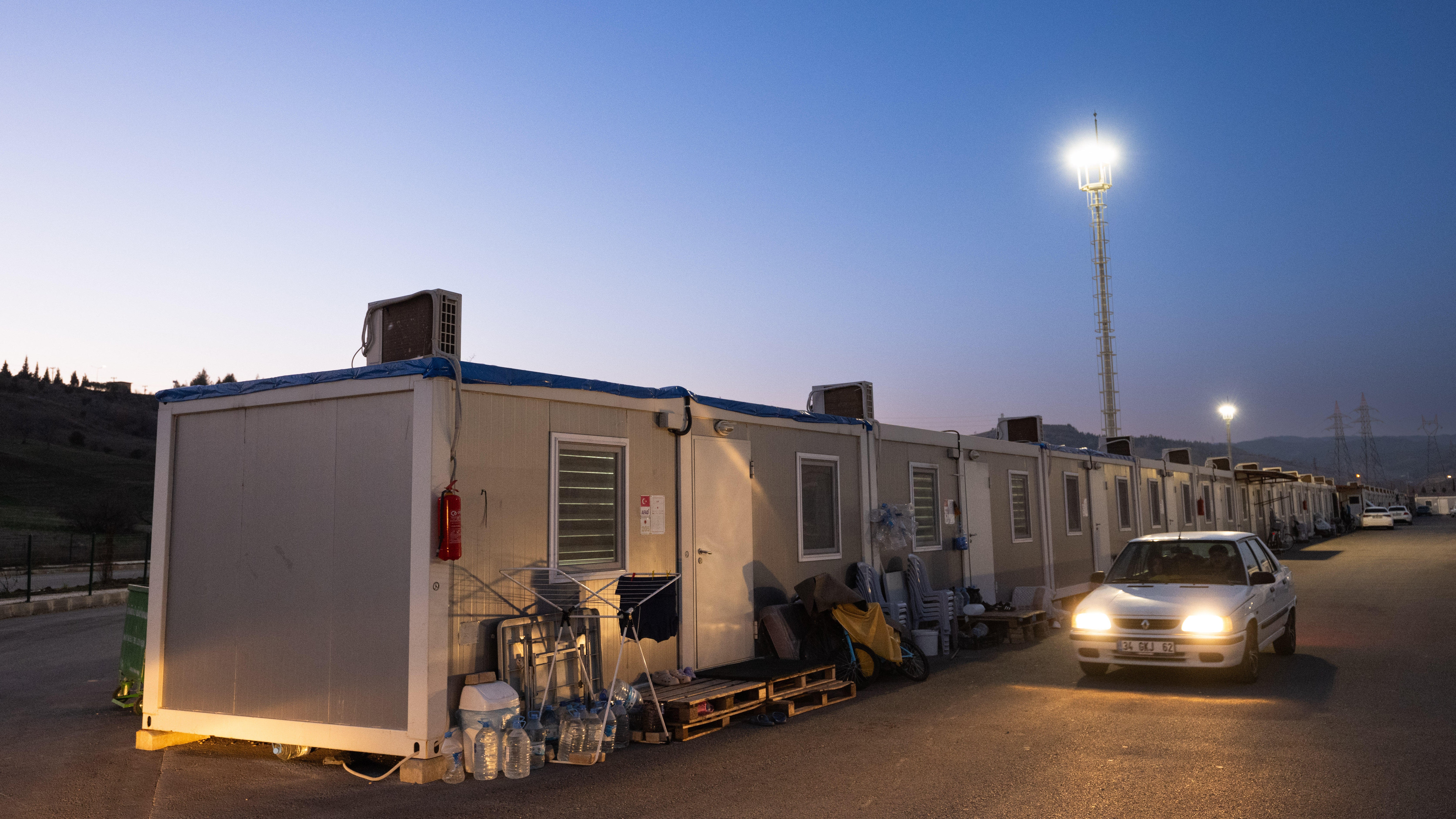 T&uuml;rkei, Kahramanmaras: Ein Auto f&auml;hrt durch ein Containerdorf (Boris Roessler/dpa)
