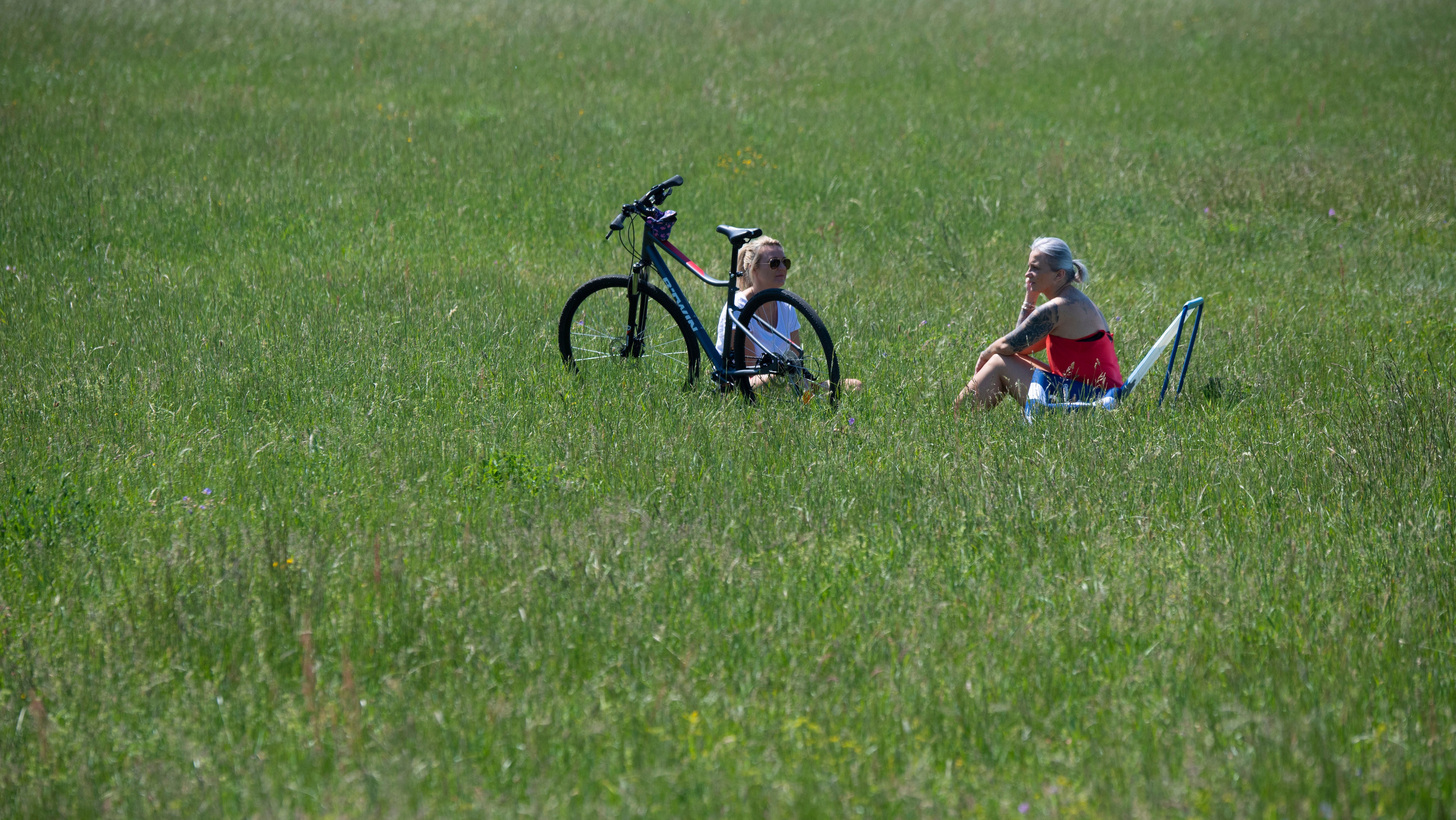 Frankfurt/Main: Zwei Frauen haben sich bei strahlendem Sonnenschein und Temperaturen von 25 Grad auf eine Wiese am Gr&uuml;ng&uuml;rtel zur&uuml;ckgezogen.