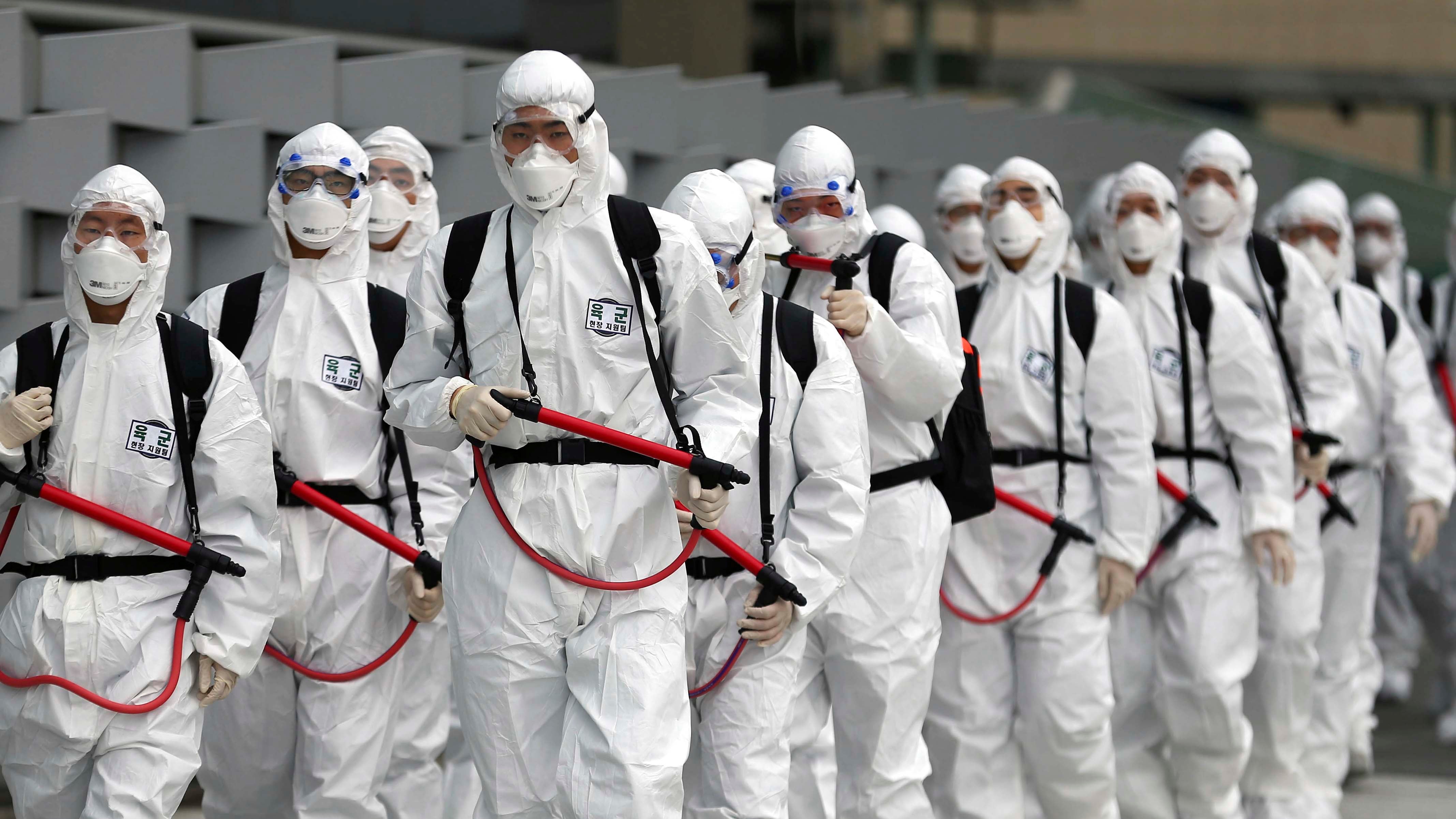 29.02.2020, S&cedil;dkorea, Daegu: Soldaten der s&cedil;dkoreanischen Armee tragen Schutzkleidung und verspr&cedil;hen Desinfektionsmittel am Bahnhof Dongdaegu. Die Zahl der Infektionsf&permil;lle mit dem neuartigen Coronavirus in S&cedil;dkorea ist binnen 24 Stunden um fast 600 gestiegen. Foto: Kim Hyun-Tai/YONHAP/AP/dpa +++ dpa-Bildfunk +++