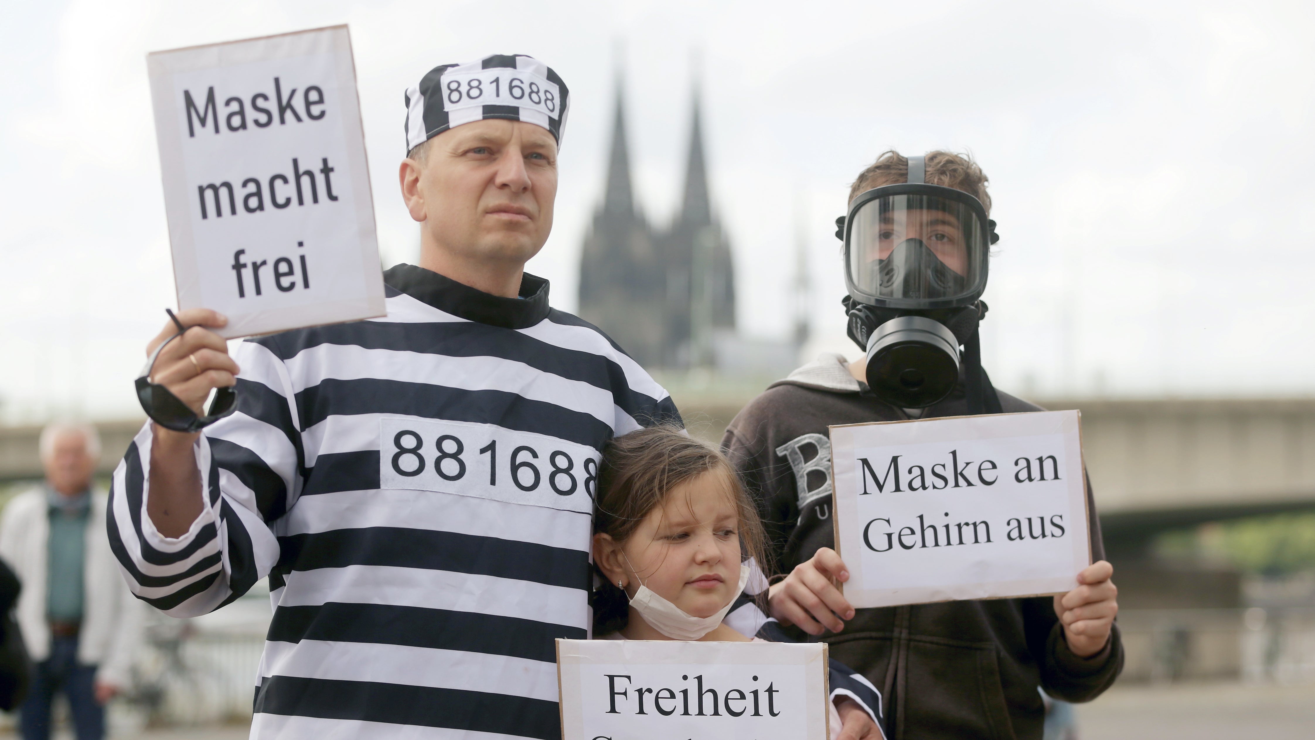 K&ouml;ln: Bei einer Demonstration gegen Corona-Beschr&auml;nkungen, ein Demonstrant im Strafgefangenen Anzug (l) h?lt einem Plakat mit dem Aufschrift "Maske macht frei".