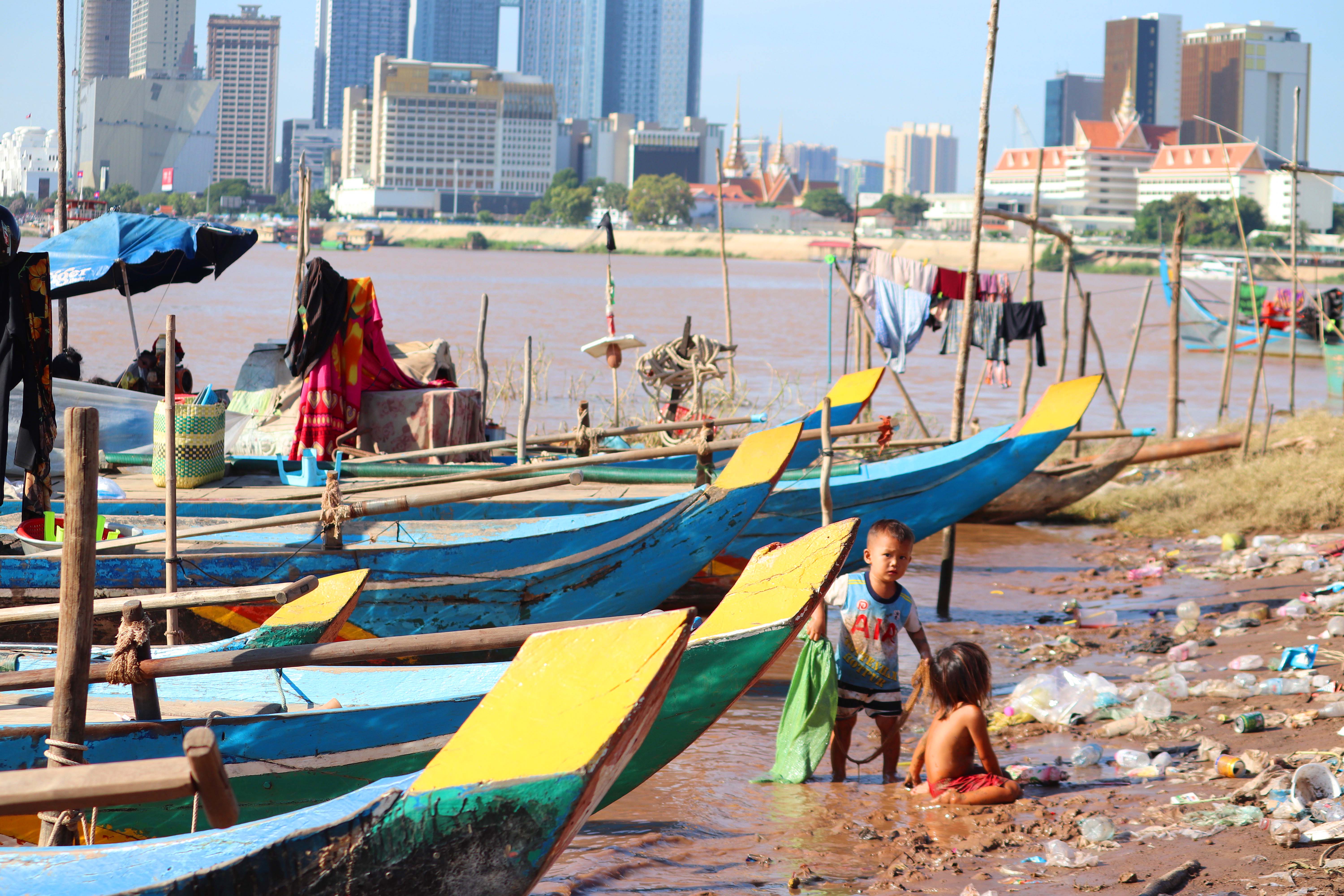 05.09.2020, Kambodscha, Phnom Penh: Kinder spielen zwischen den Fischerbooten, die auf der Chroy-Changvar-Halbinsel, am Zusammenfluss von Mekong und dem  Tonle Sap, an Land liegen. Das Mekong-Flussbett auf der Chroy-Changvar-Halbinsel f&cedil;hrt kaum Wasser, im matschigen Boden h&permil;uft sich M&cedil;ll. Dabei ist der Strom, der durch ein halbes Dutzend L&permil;nder S&cedil;dostasiens flieﬂt, f&cedil;r die Ern&permil;hrung und den Lebensunterhalt von gesch&permil;tzten 60 Millionen Menschen von lebenswichtiger Bedeutung. (zu dpa "D&cedil;rre am Mekong: S&cedil;dostasiens Lebensader trocknet aus") Foto: Shaun Turton/dpa +++ dpa-Bildfunk +++