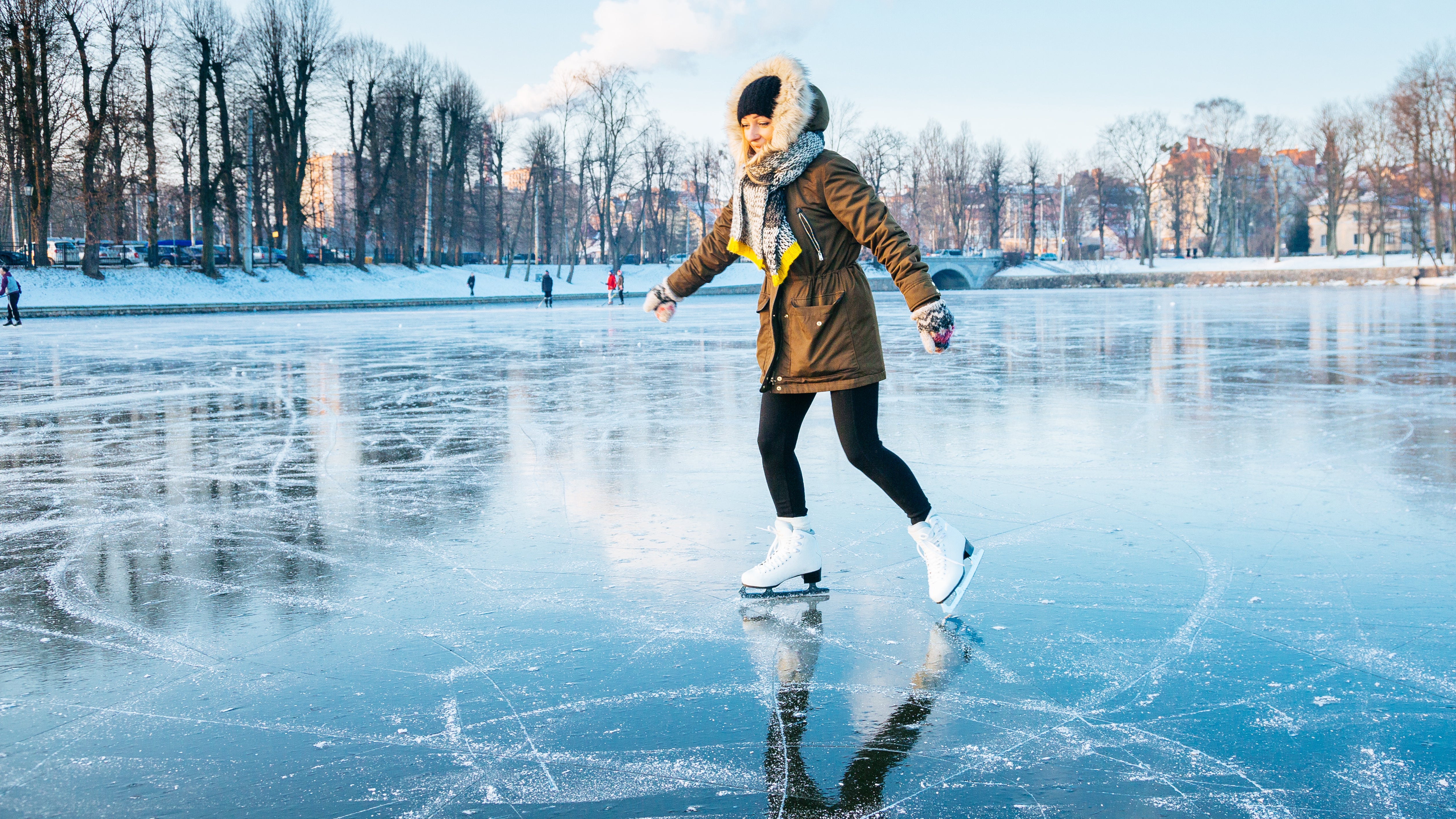 Eine Frau f&auml;hrt Schlittschuh auf einem zugefrorenen See