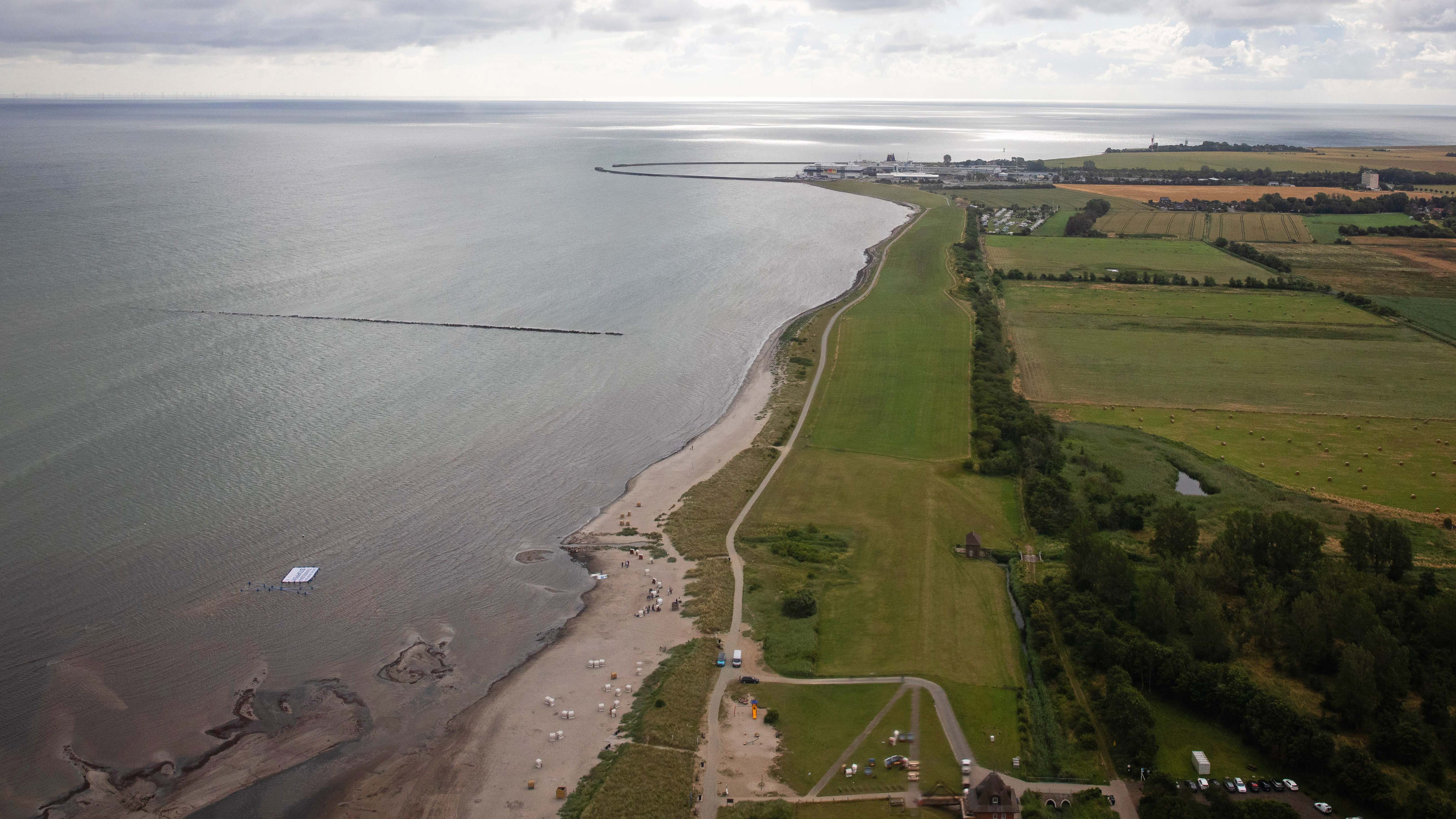 ARCHIV - 12.07.2020, Schleswig-Holstein, Fehmarn: Die Ostseek&cedil;ste am Naturschutzgebiet Gr&cedil;ner Brink nahe dem F&permil;hranleger Puttgarden, wo Unterst&cedil;tzer und Aktivisten der Protestaktion "Beltretter" ein Banner mit dem Text "Ostsee sch&cedil;tzen. Tunnelbau stoppen!" und ein blaues Kreuz zeigen, w&permil;hrend sie in der Ostsee stehen. &dagger;Der geplante Ostseetunnel als feste Fehmarnbeltquerung bleibt unter Bef&cedil;rwortern und Gegnern hoch umstritten. (zu dpa "Umstrittenes Milliardenprojekt Tunnel unter der Ostsee") Foto: Christian Charisius/dpa +++ dpa-Bildfunk +++