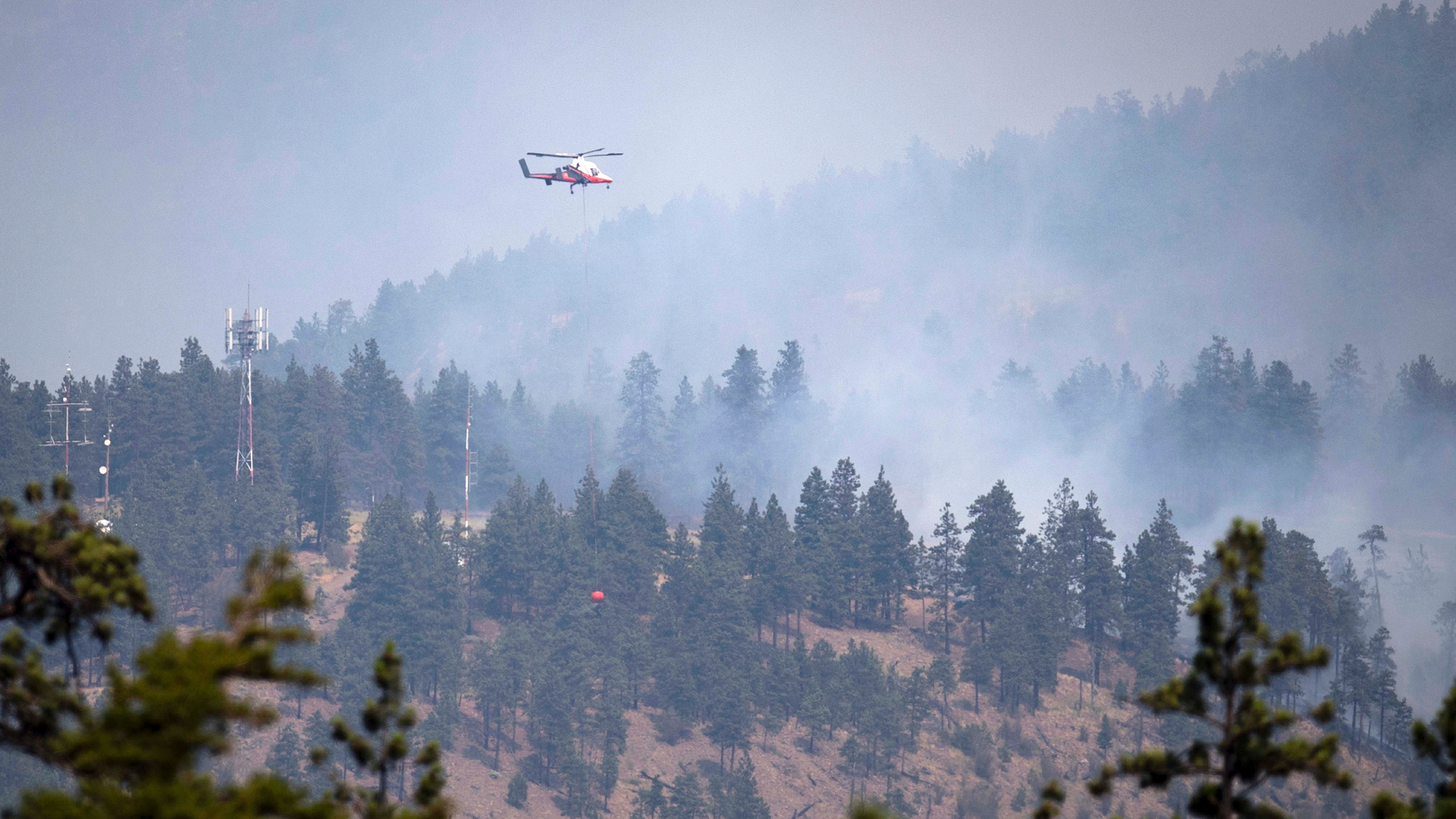 02.07.2021, Kanada, Lytton: Ein Hubschrauberpilot bereitet sich darauf vor, Wasser auf ein brennendes Waldfeuer in Lytton, British Columbia, abzuwerfen. Erst eine extreme Hitzewelle mit Temperaturen bis 50 Grad, dann ein Flammenmeer: Die kanadische Ortschaft Lytton ist fast komplett zerst&circ;rt worden. Im Westen Nordamerikas brennt es an vielen Stellen. Meteorologen sprechen von einem &acute;noch nie dagewesenen Ereignis&ordf;. Foto: Darryl Dyck/The Canadian Press/dpa - ACHTUNG: Nur zur redaktionellen Verwendung und nur mit vollst&permil;ndiger Nennung des vorstehenden Credits +++ dpa-Bildfunk +++
