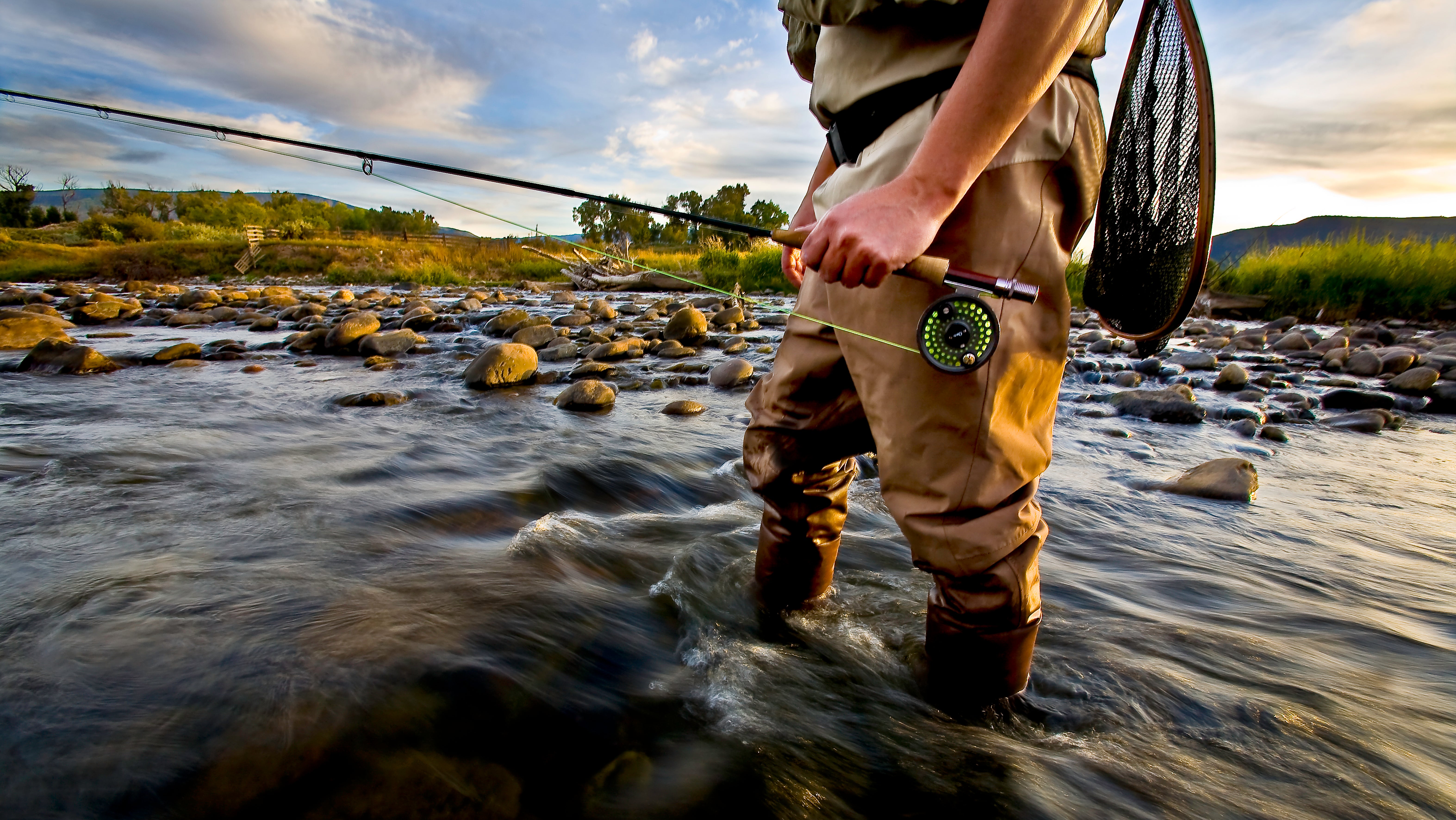 Ein Angler steht in einem Fluss