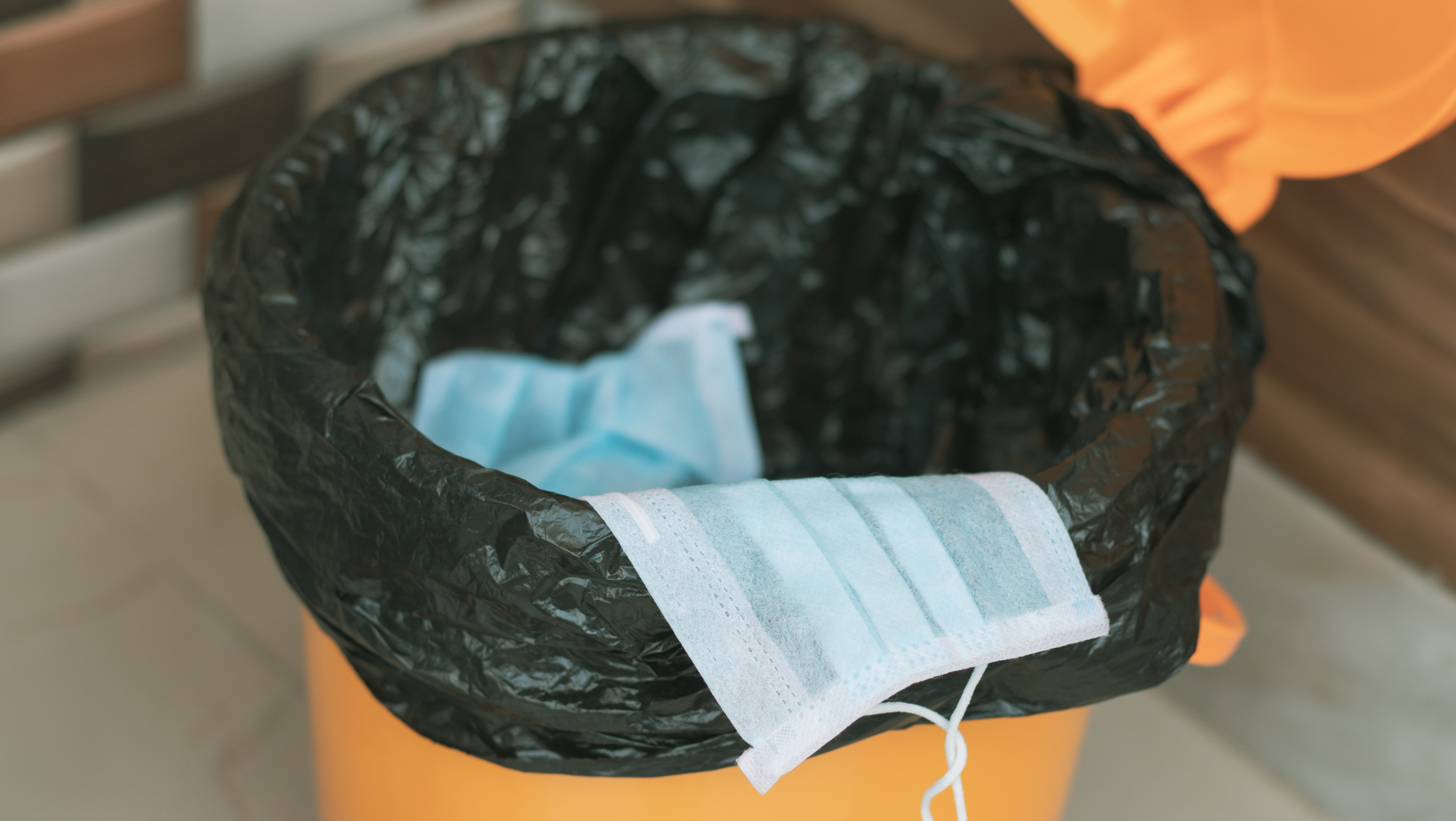 Eine Maske wird im M&uuml;ll entsorgt