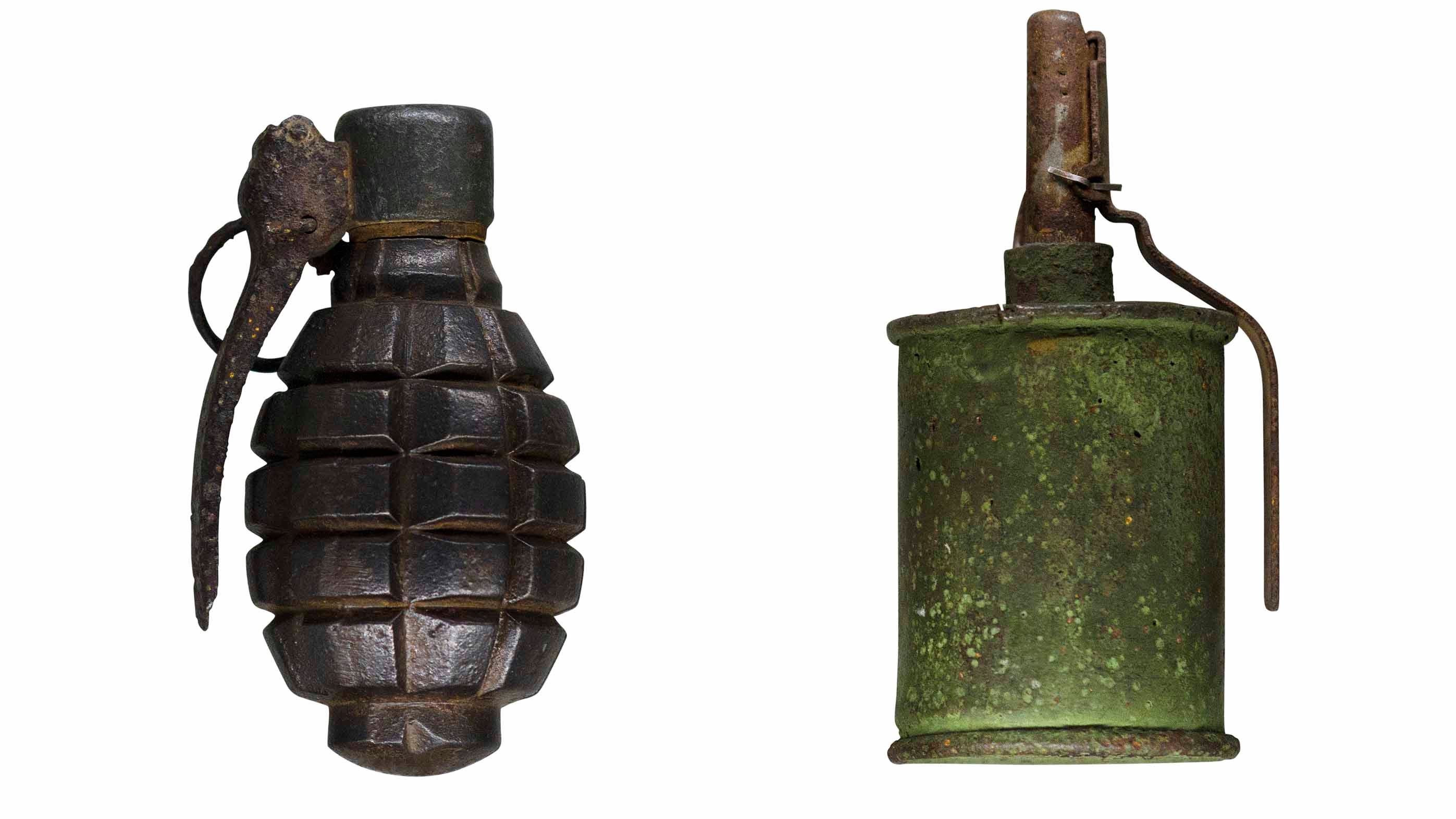 Two World War 2 hand grenades. Rusty and scratched. Isolated on white background.