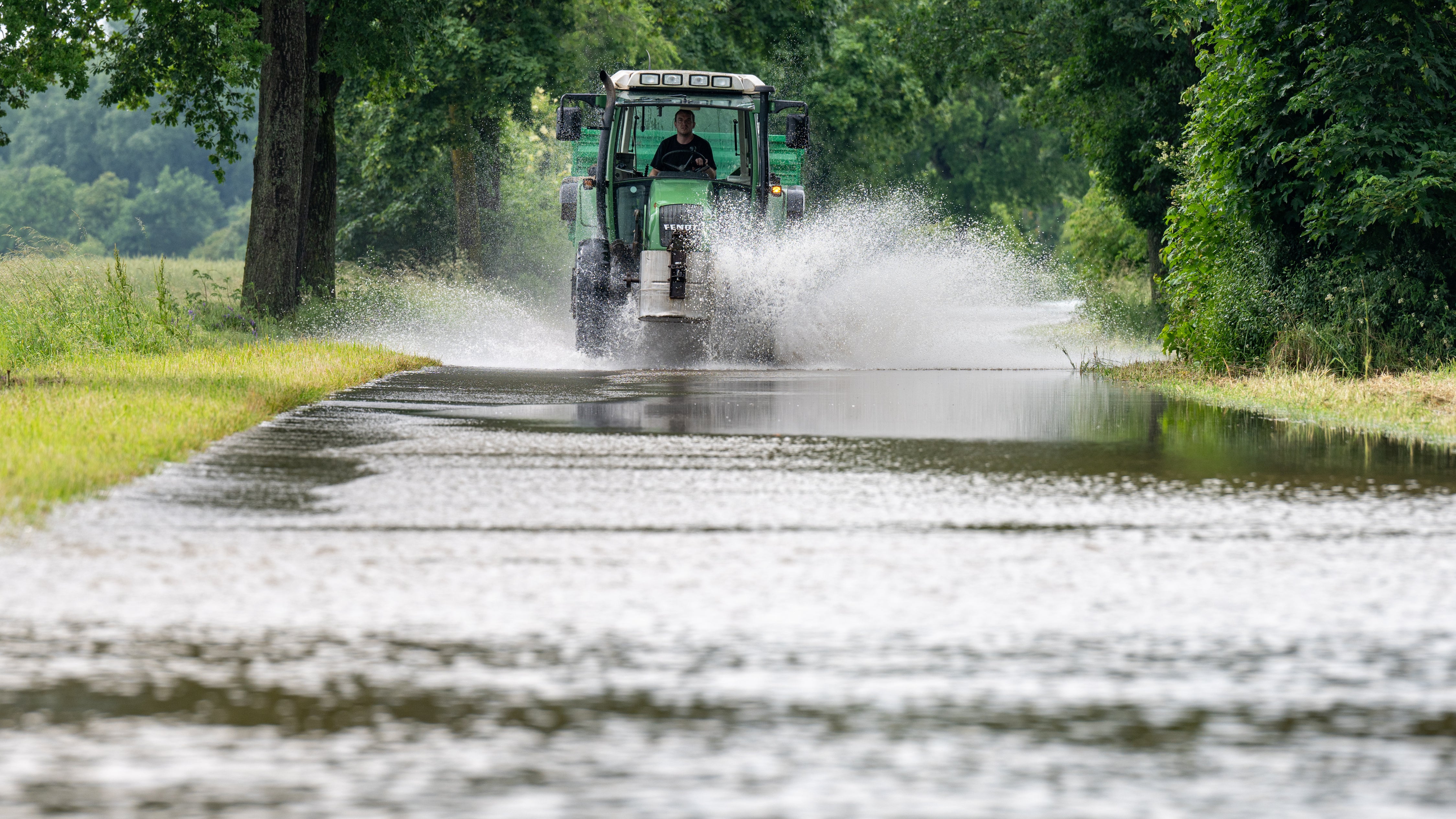 02.06.2024, Bayern, Baar-Ebenhausen: Ein Traktor f&auml;hrt in Baar-Ebenhausen durch eine &uuml;berflutete Stra&szlig;e. Extremer Dauerregen in Bayern, In wehreren drei Landkreisen gilt der Katastrophenfall. (Armin Weigel/dpa)