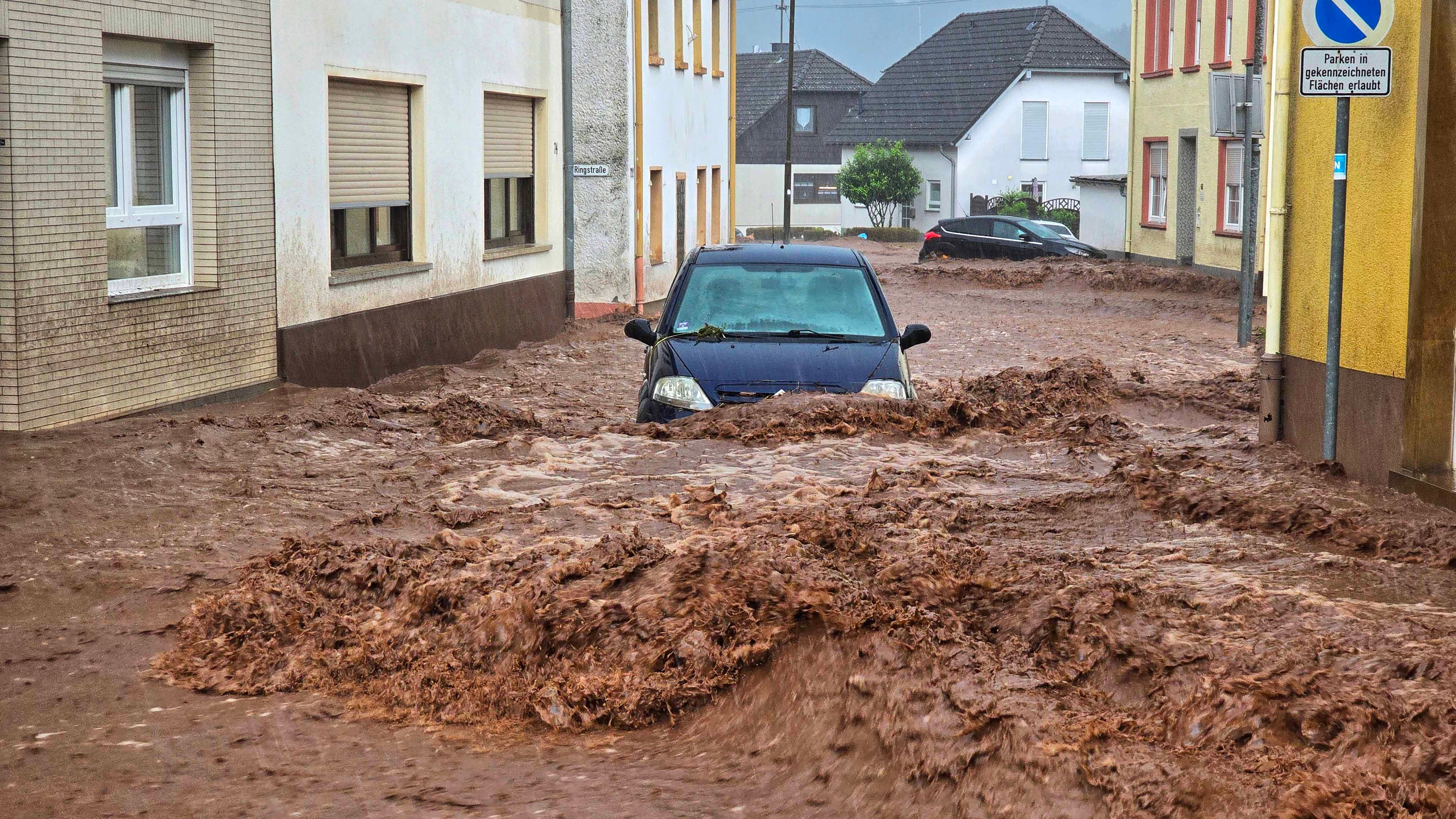19.05.2024, Rheinland-Pfalz, Kirn: Ein Auto bahnt sich den Weg durch die Wassermassen. Extremer Starkregen hat am Sonntagnachmittag in der rheinland-pf&permil;lzischen Stadt Kirn zu &lsaquo;berflutungen und Erdrutschen gef&cedil;hrt. Foto: Sebastian Schmitt/dpa +++ dpa-Bildfunk +++