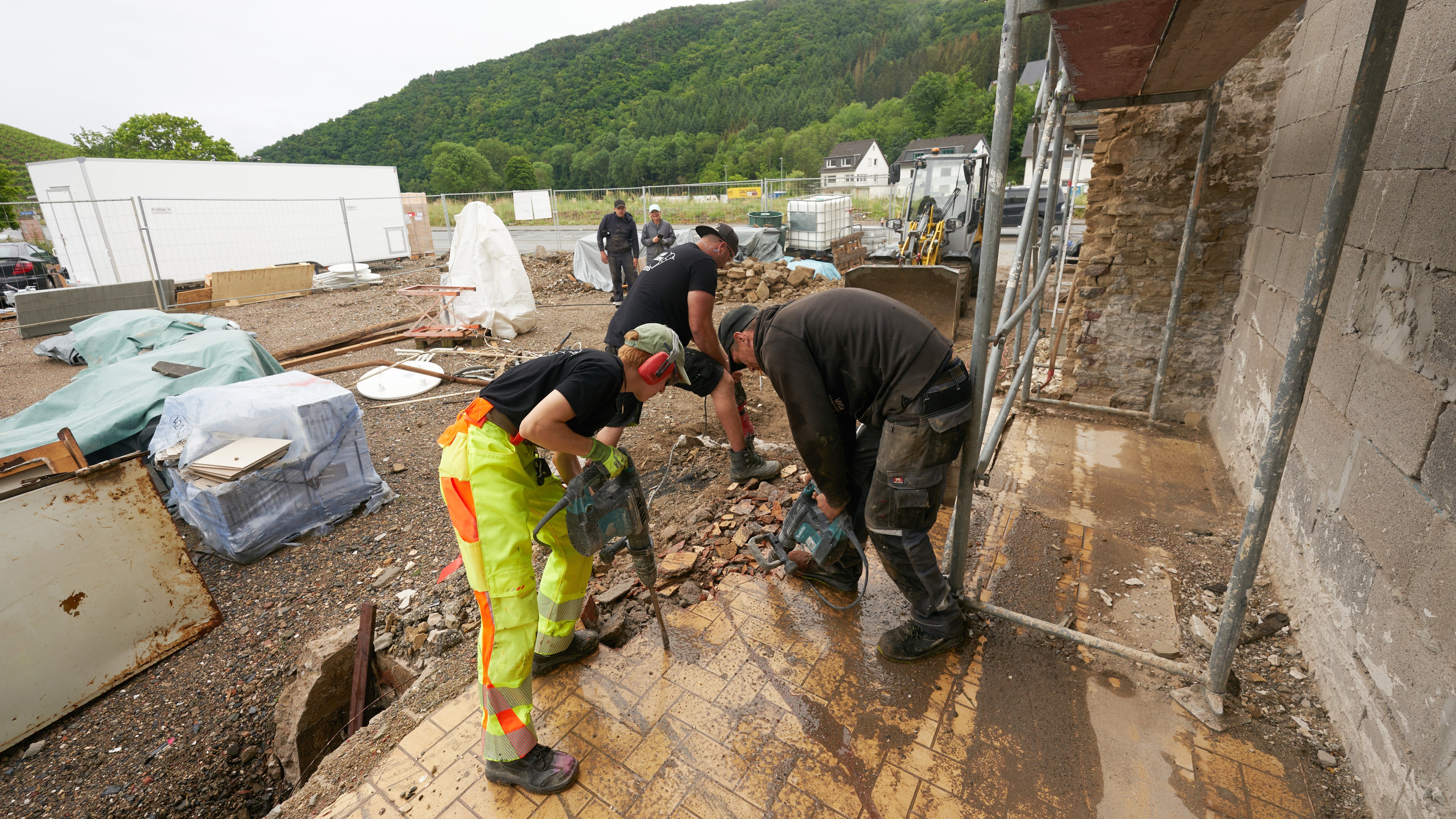 PRODUKTION - 08.06.2022, Rheinland-Pfalz, Dernau: Anny, Dennis und Pomp vom &middot;Team Ballern&middot; stemmen in Dernau die Reste des Fundaments eines abgerissenen Hauses weg. (zu dpa-KORR "Hochwasserbabys und Helfersyndrom - Wandel der Fluthilfe im Ahrtal") Foto: Thomas Frey/dpa +++ dpa-Bildfunk +++