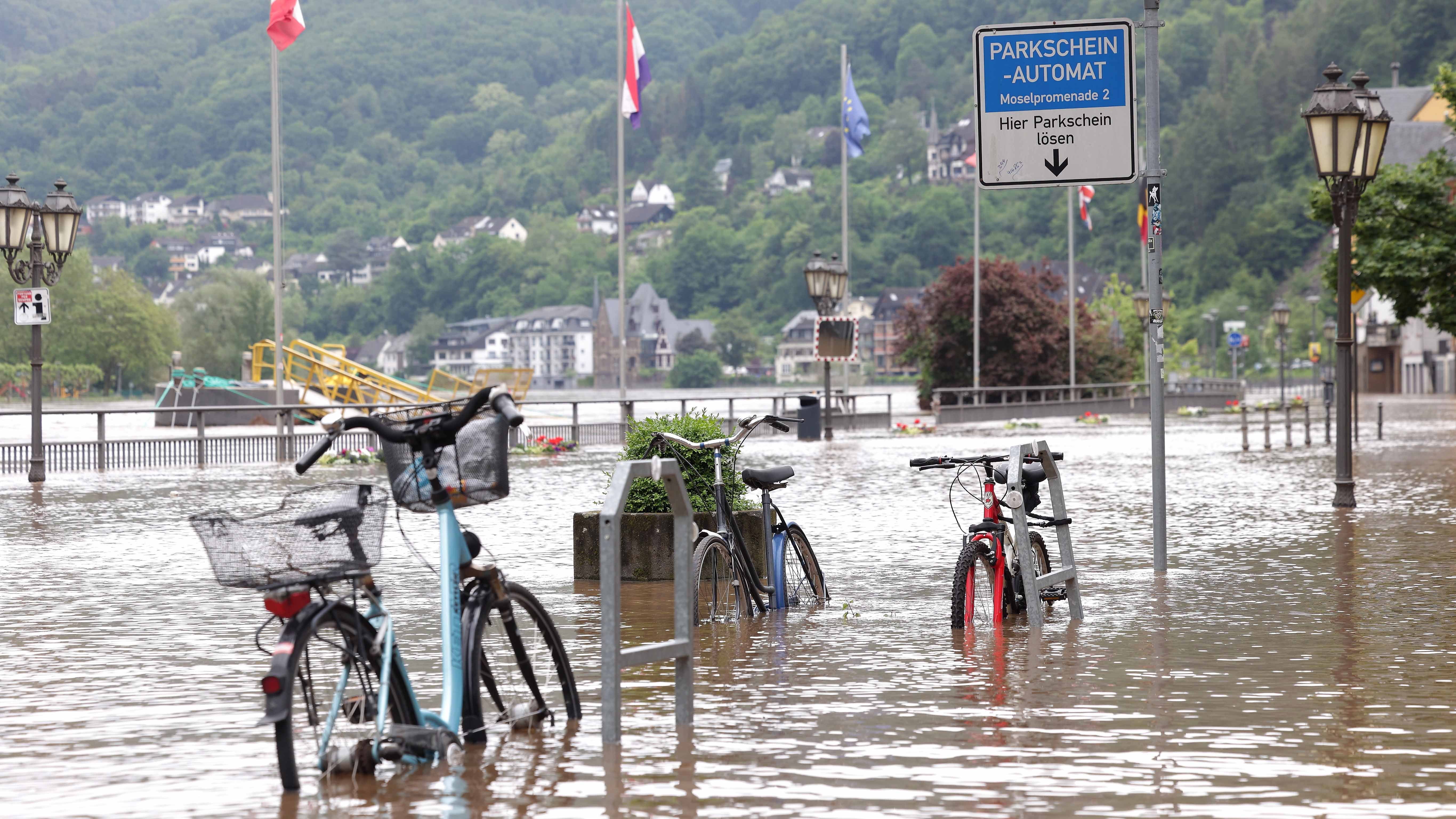 dpatopbilder - 18.05.2024, Rheinland-Pfalz, Cochem: Fahrr&permil;der stehen im Wasser auf der &cedil;berfluteten Promenade an der Mosel. Heftiger Dauerregen hat Fl&cedil;sse &cedil;ber die Ufer treten lassen und &lsaquo;berschwemmungen verursacht. Foto: David Young/dpa +++ dpa-Bildfunk +++