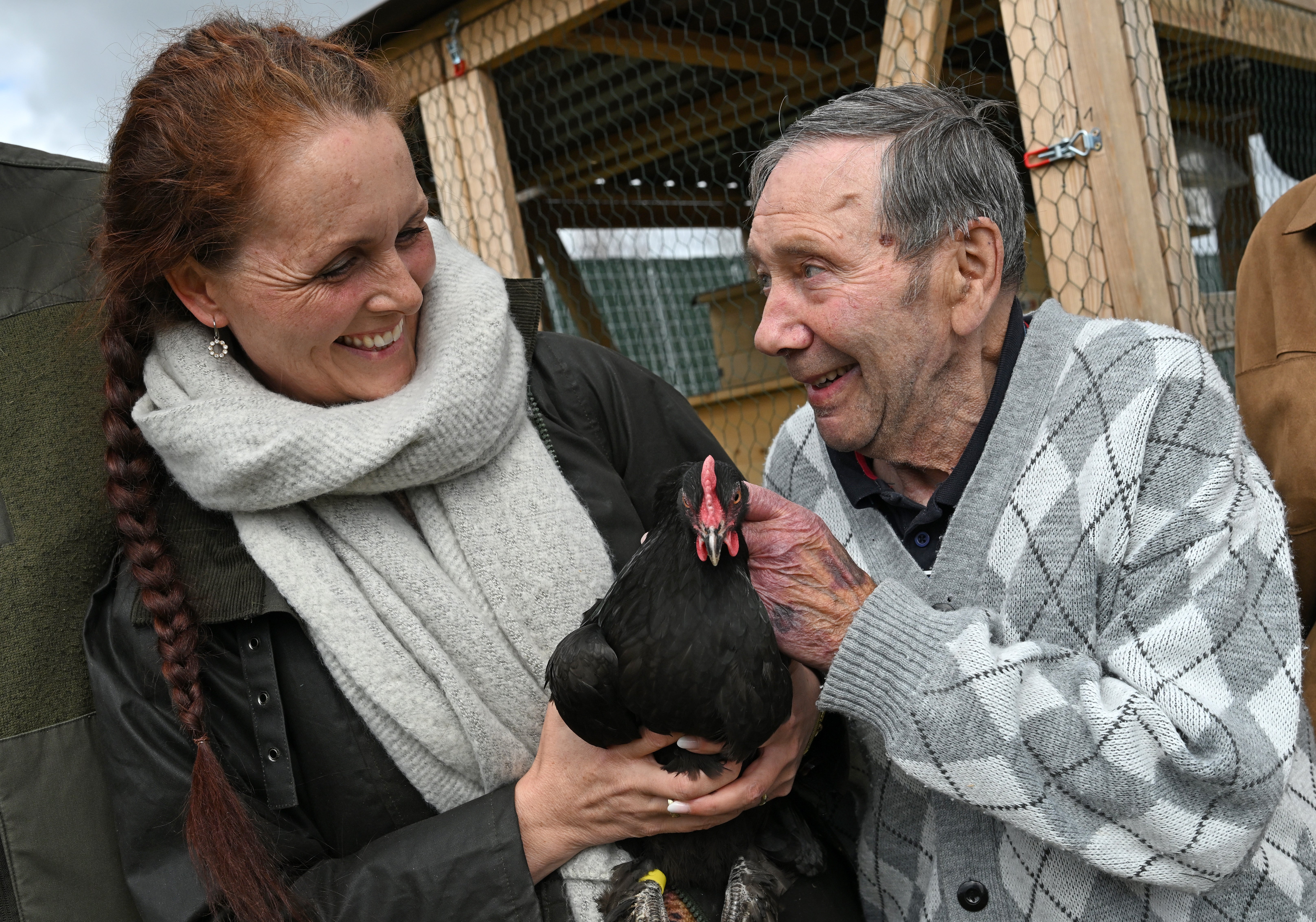 ACHTUNG: Nur zur redaktionellen Verwendung (bis zum Datum) im Zusammenhang mit einer Berichterstattung &uuml;ber den Film und nur mit vollst&auml;ndiger Nennung des Credits 

31.03.2026, Th&uuml;ringen, Milda: Dieter Schmidt, 77-j&auml;hriger Bewohner des Pflegeheims "Landhaus Mildaer Hof" und Lina Angrick, Eigent&uuml;merin der Mieth&uuml;hner, halten die schwarze Henne Cragi im Garten seines Pflegeheims in den H&auml;nden. (Martin Schutt/dpa)