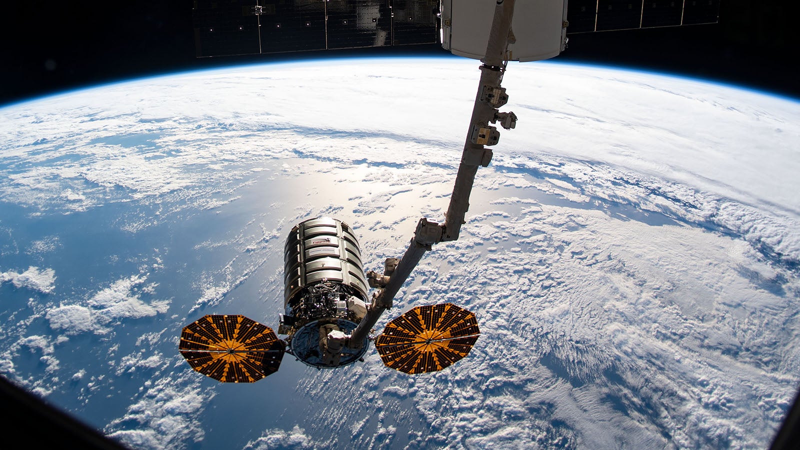 HANDOUT - 06.08.2019, ---, Weltall: ARCHIV&nbsp;- Der Roboterarm Canadarm2 ist ausgefahren, um den Cygnus-Raumtransporter (unten, Mitte) an der Internationalen Raumstation ISS festzuhalten. Mit mehr als 3700 Kilogramm Nachschub und technischer Ausstattung an Bord ist der private Raumfrachter &laquo;Cygnus&raquo;&nbsp;erneut zur Internationalen Raumstation ISS gestartet. Foto: Nasa/dpa - ACHTUNG: Nur zur redaktionellen Verwendung und nur mit vollst&auml;ndiger Nennung des vorstehenden Credits +++ dpa-Bildfunk +++