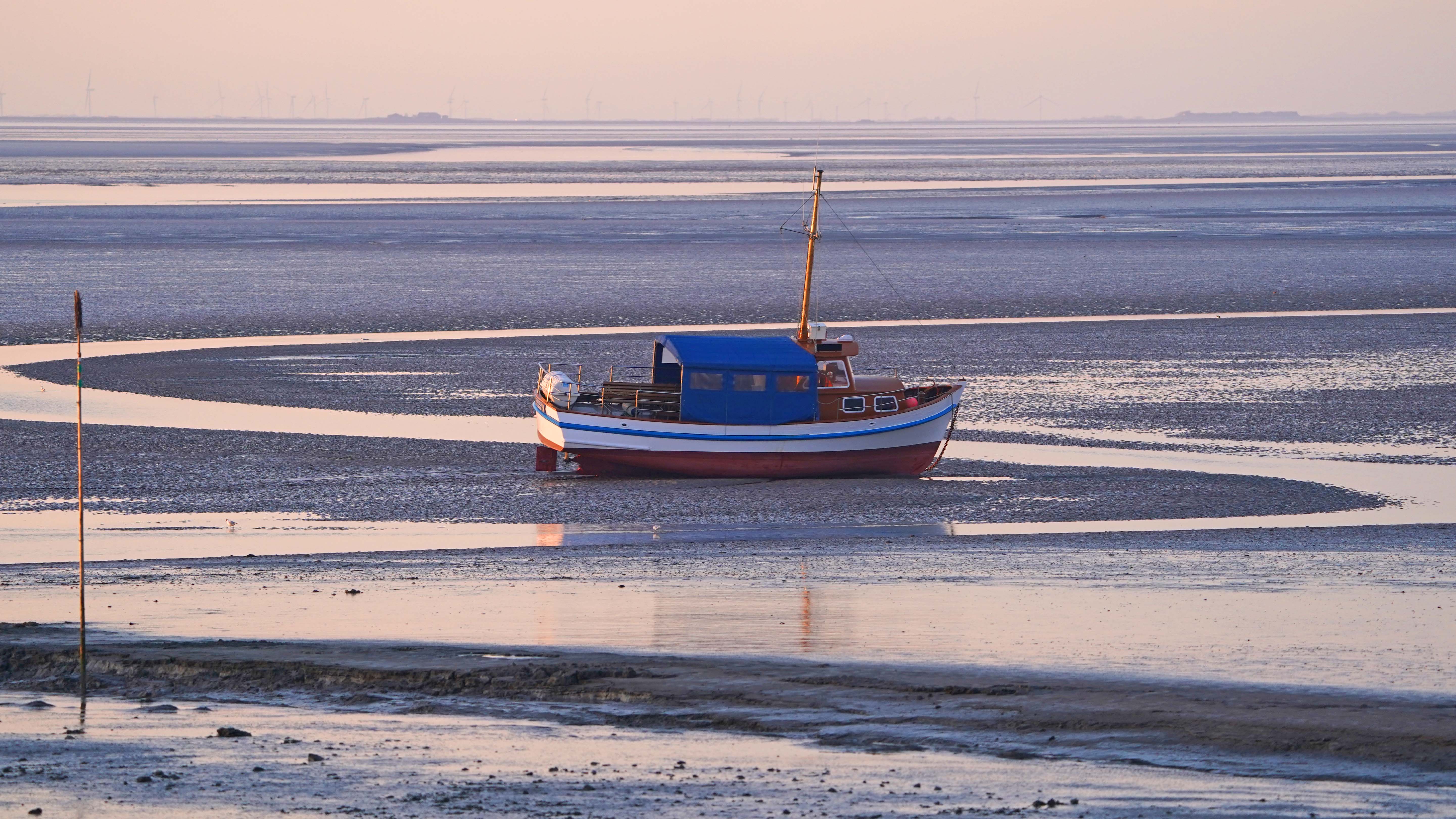 10.05.2021, Schleswig-Holstein, Pellworm: Ein Boot liegt im Watt vor der Nordseeinsel Pellworm. Die gr&cedil;ne nordfriesische Insel f&cedil;hrt eher ein Schattendasein im Vergleich zu ihren Schwestern Sylt, Amrum und F&circ;hr. (zu dpa "Kein Hauch von Sylt - Pellworm im Schatten ihrer Schwestern") Foto: Marcus Brandt/dpa +++ dpa-Bildfunk +++