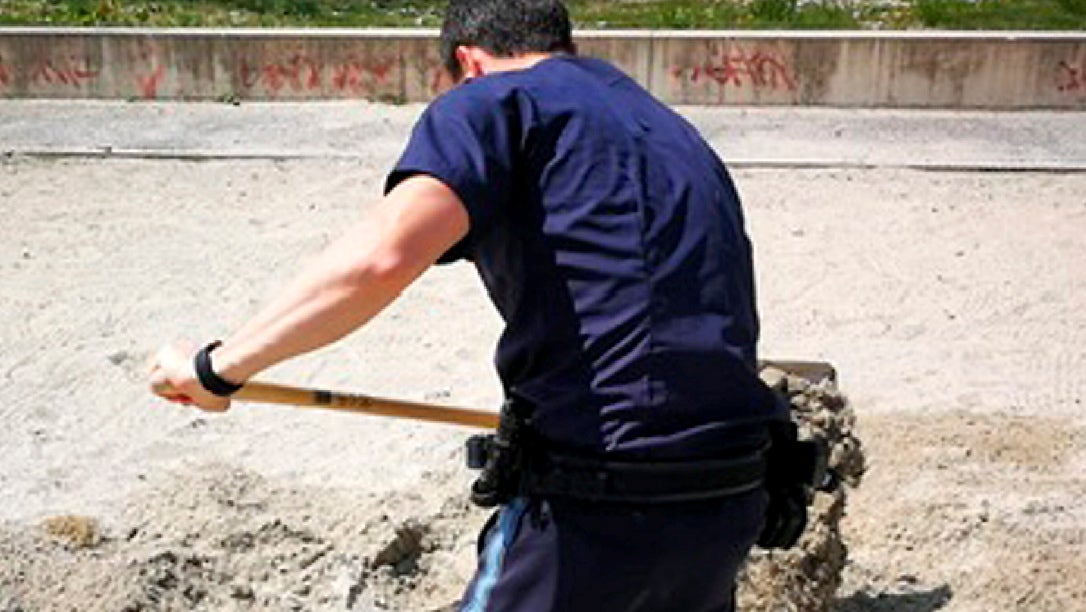 Ein Polizeibeamter gr&auml;bt im Sandkasten eines Spielplatzes. Polizisten haben vier Kaninchen-Babys aus ihrem eingest&uuml;rzten Bau in M&uuml;nchen gerettet.