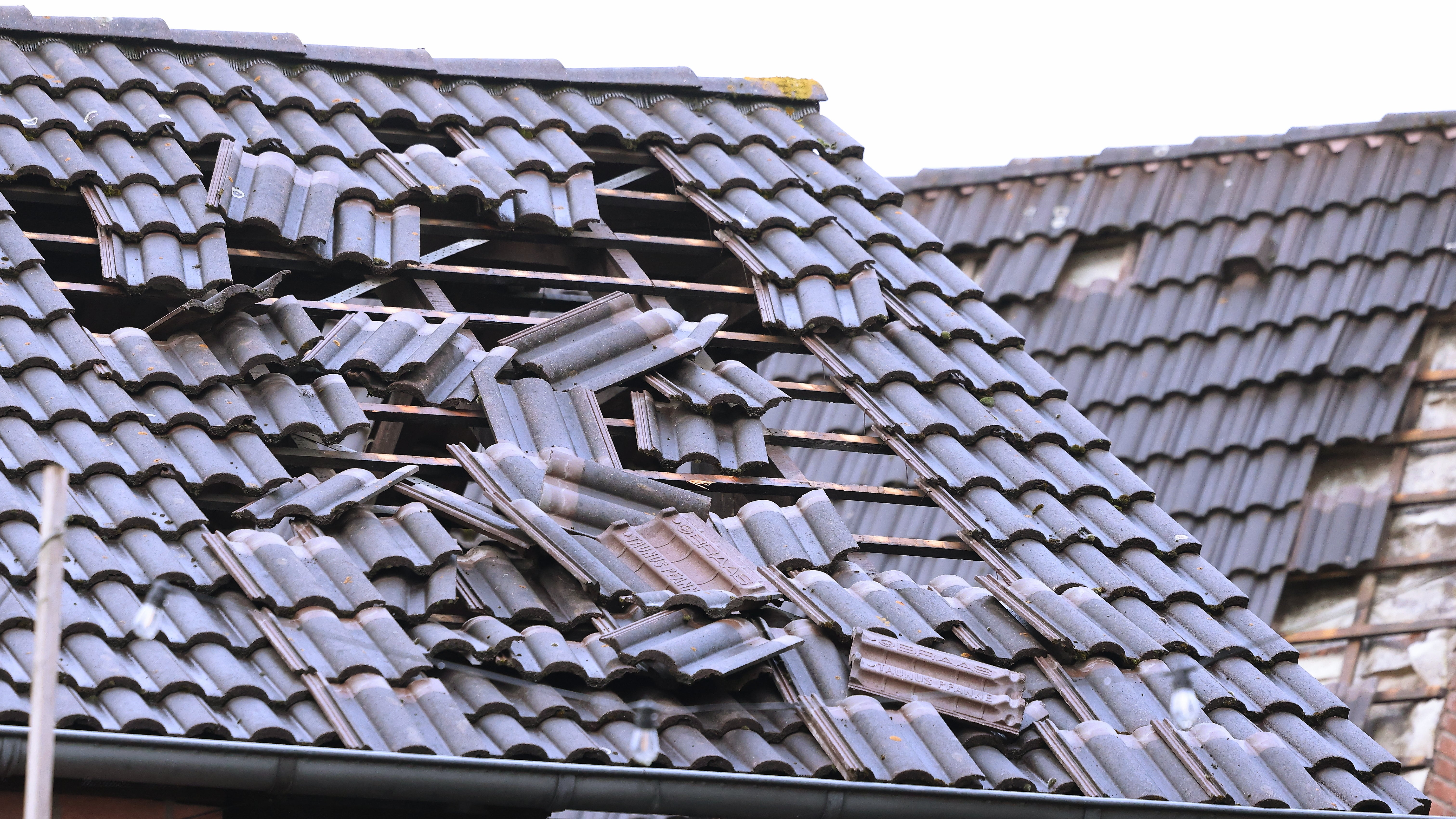 05.04.2024, Nordrhein-Westfalen, Korschenbroich: Ein Schild liegt nach einem Unwetter auf einer Stra&szlig;e. In Korschenbroich bei M&ouml;nchengladbach hat am Donnerstag m&ouml;glicherweise ein Tornado ungef&auml;hr 20 H&auml;user besch&auml;digt. (David Young/dpa)

