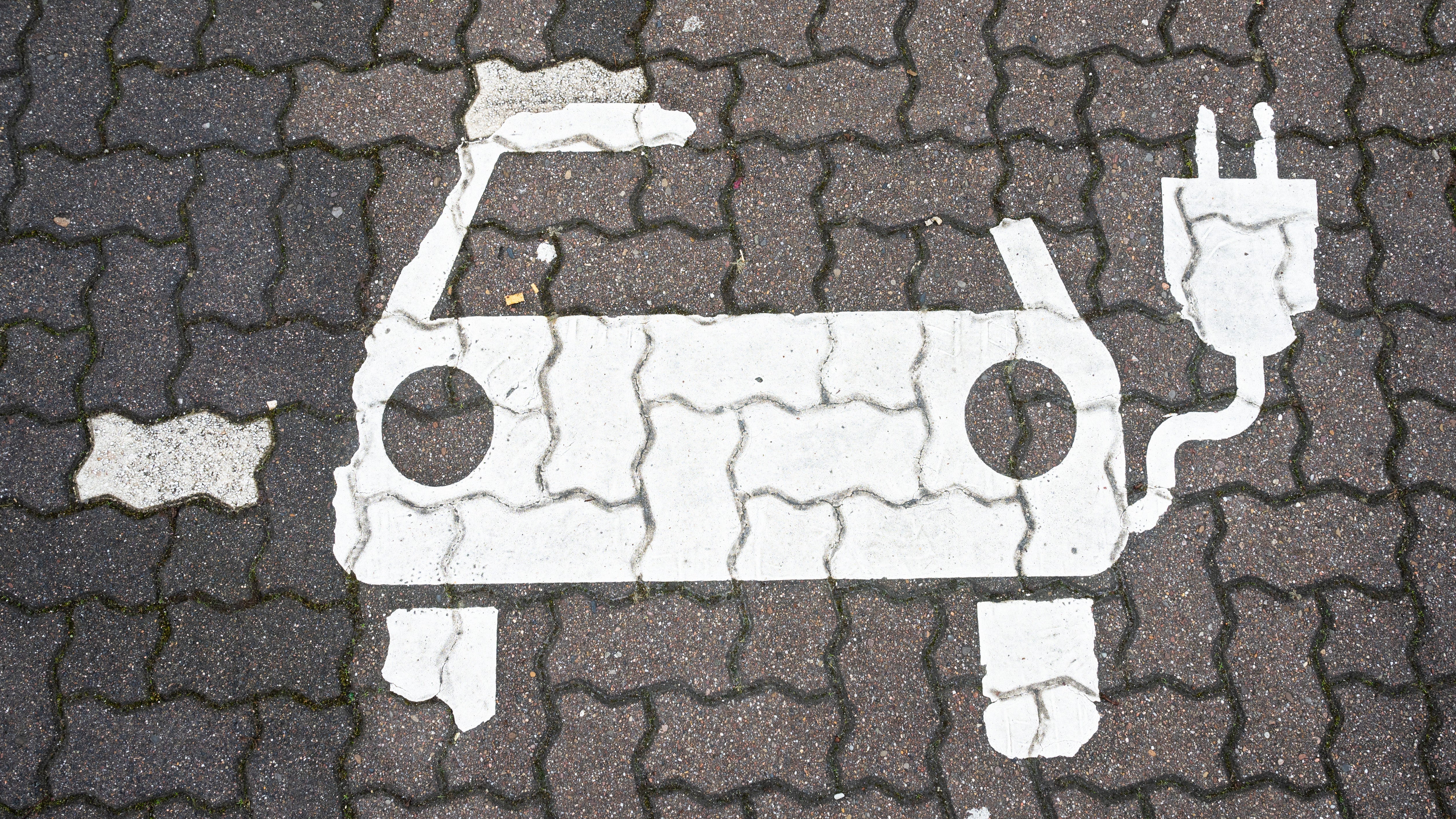Ein Symbol markiert einen Parkplatz f&uuml;r Elektroautos an Lades&auml;ulen f&uuml;r E-Auto an einem Rastplatz an der Autobahn A2.