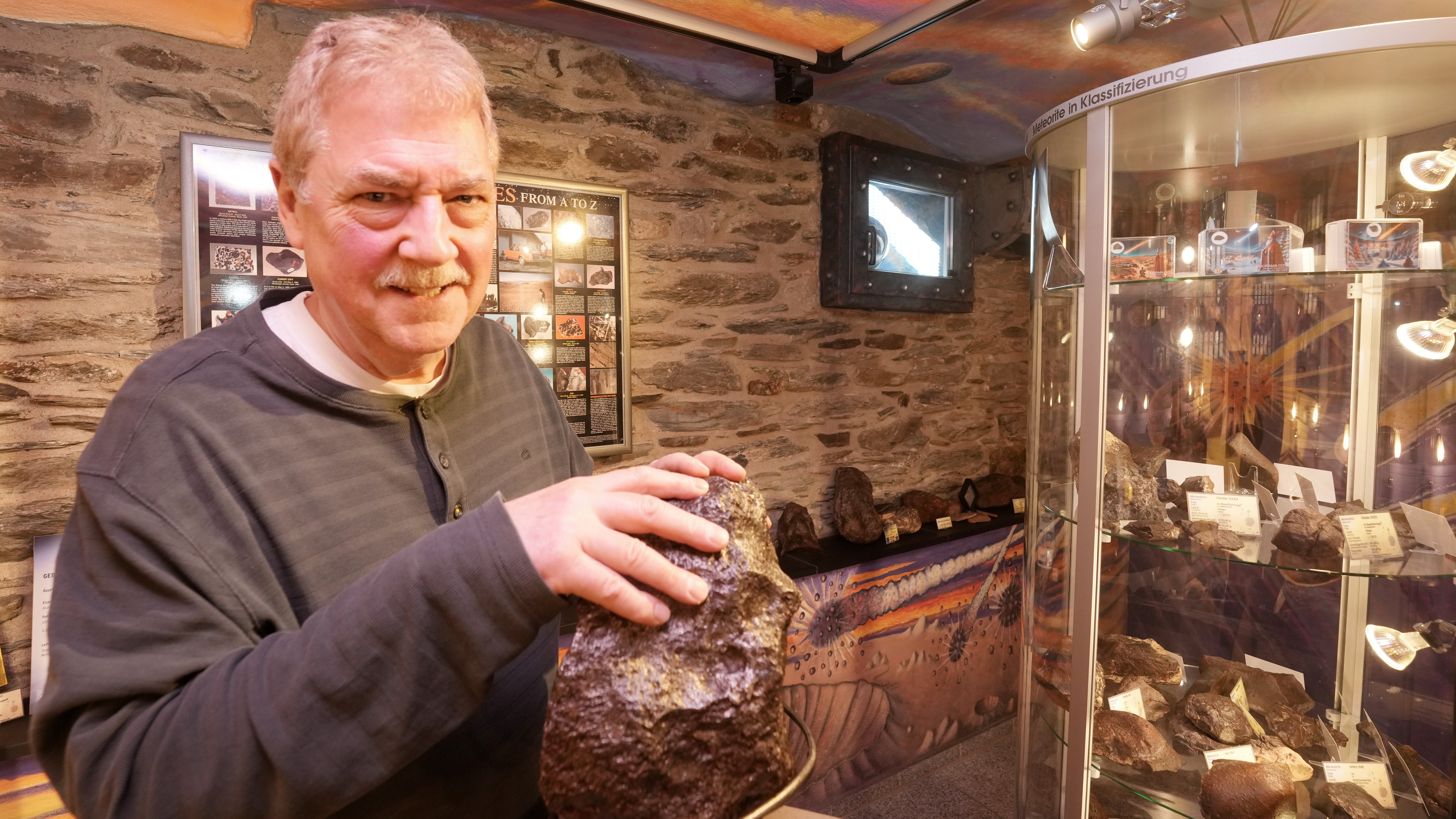 10.03.2026, Rheinland-Pfalz, Oberwesel: Stephan Decker, Inhaber des Meteorite-Museums Oberwesel, ber&uuml;hrt einen 43 kg schweren Campo del Cielo Eisenmeteoriten aus Argentinien. (Thomas Frey/dpa)

