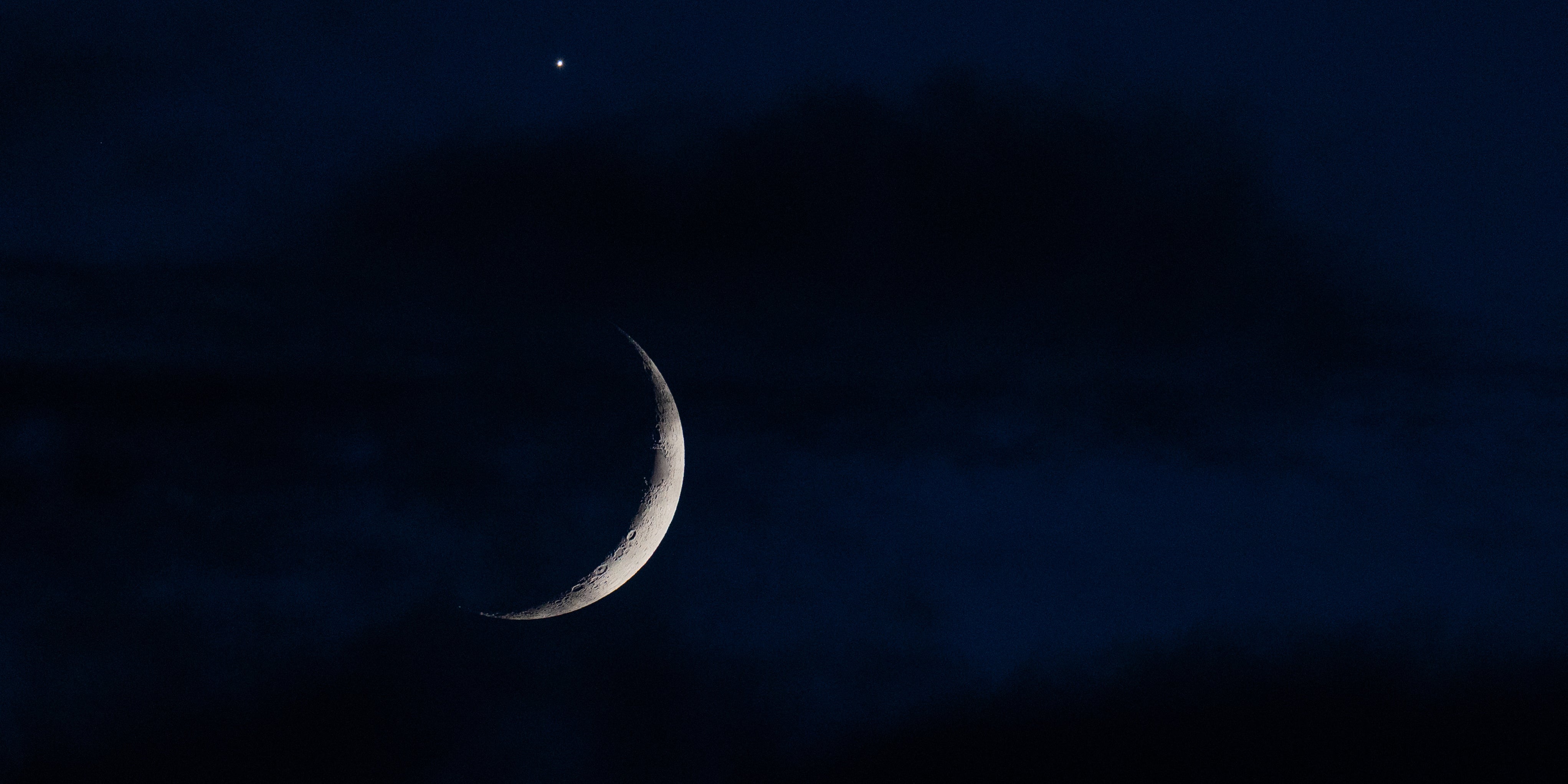 17.06.2026, Nordrhein-Westfalen, K&ouml;ln: Der sichelf&ouml;rmige Mond wird am Abend hinter Wolken von der Venus (oben) begleitet. (Rolf Vennenbernd/dpa)