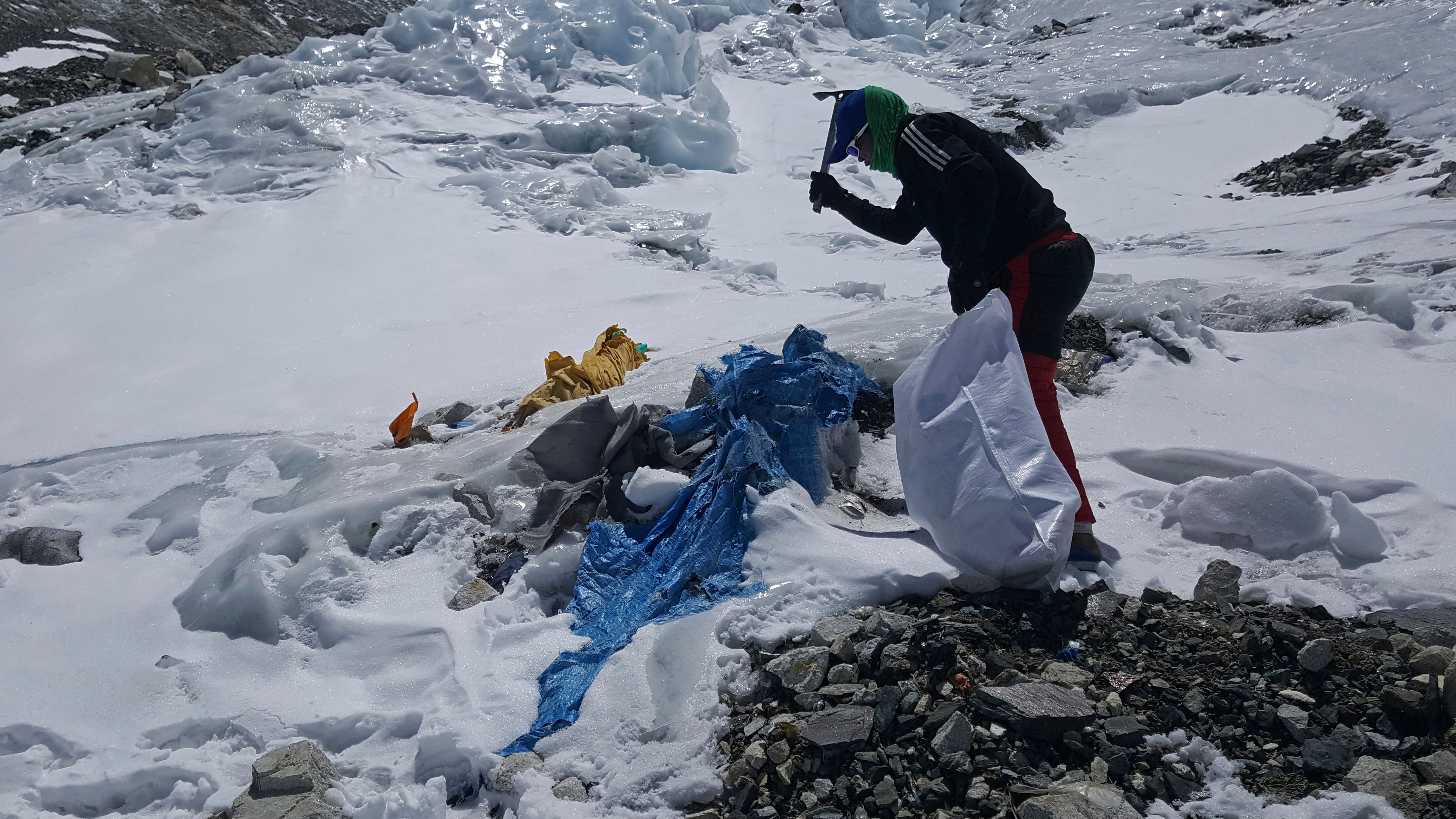 Nepal, Dienstag, 27. April 2021: Dieses von der Peak Promotion zur Verf&uuml;gung gestellte Bild zeigt ein Mitglied des von der nepalesischen Regierung finanzierten Teams, das mit einem Spaten gefrorene Abf&auml;lle auf dem Weg zum Mount Everest entfernt.