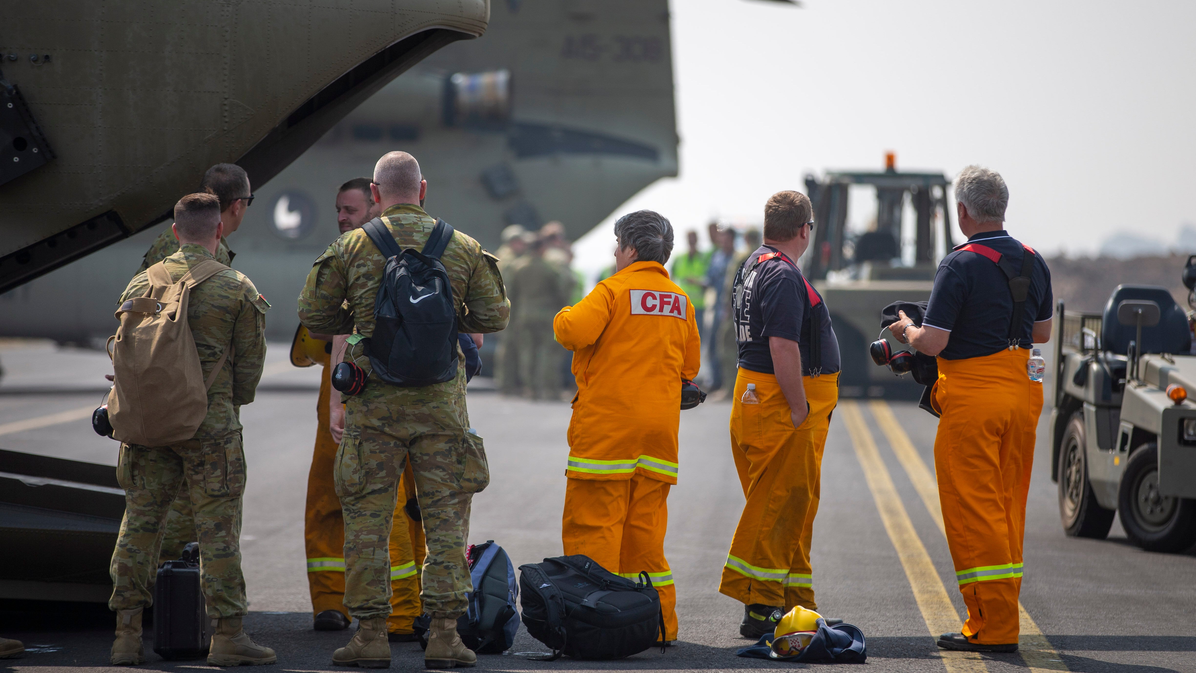 Soldaten und Mitglieder der Country Fire Authority stehen kurz vor Boarding auf dem Milit&auml;rflugplatz RAAF Base East Sale. Im Kampf gegen die verheerenden Buschbr&auml;nde will Premierminister Morrison 3000 Reservisten der Streitkr&auml;fte mobilisieren.