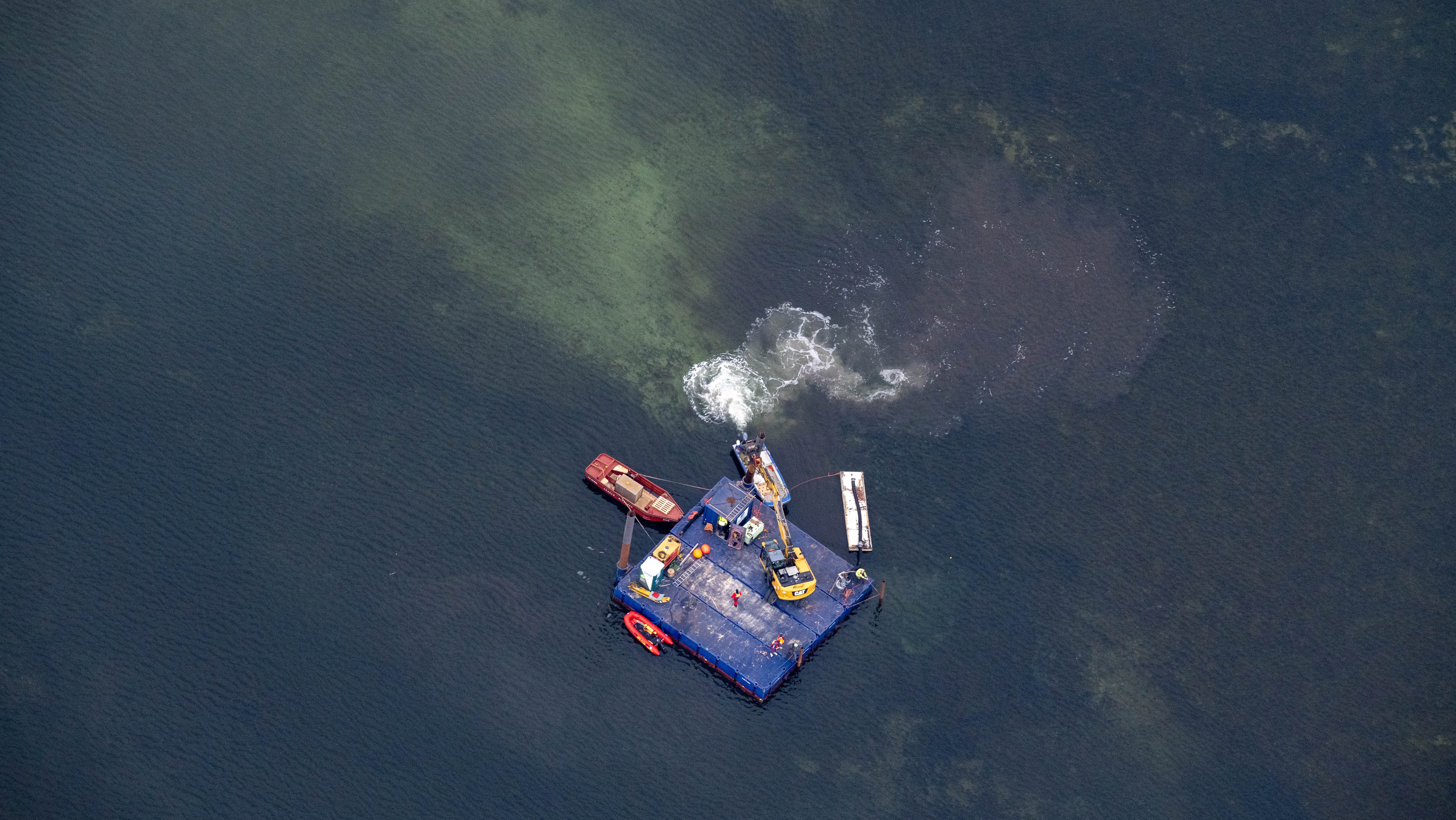 18.04.2026, Mecklenburg-Vorpommern, Wismar: Ein Arbeitsponton mit einem Bagger und kleinere Begleitboote n&auml;hern sich dem gestrandeten Buckelwal vor der Insel Poel. F&uuml;r den bei Wismar gestrandeten Buckelwal soll ein neuer Rettungsversuch erfolgen. Umgesetzt werden soll das Konzept von einer privaten Initiative. (Stefan Sauer/dpa)