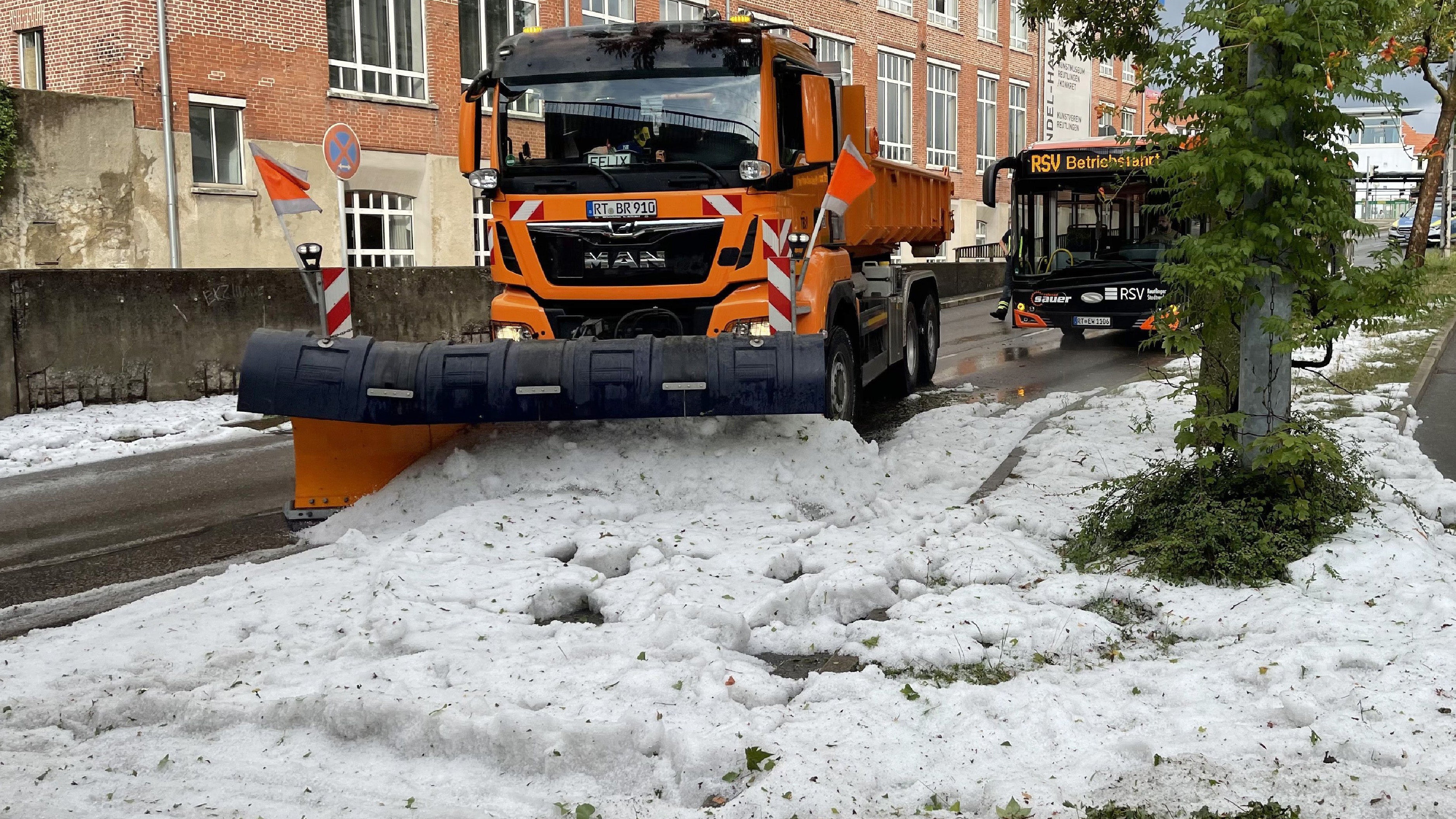 04.08.2023, Baden-W&uuml;rttemberg, Reutlingen: Die Technischen Betriebsdienste r&uuml;cken mit Schneepfl&uuml;gen an um den Hagel von der Stra&szlig;e zu r&auml;umen. Winterdienst-Einsatz mitten im Sommer: Ein lokal begrenztes Unwetter hat Stra&szlig;en in der Innenstadt von Reutlingen mit einer hohen Hagel-Schicht &uuml;berzogen. Foto: Schulz/SDMG/dpa +++ dpa-Bildfunk +++