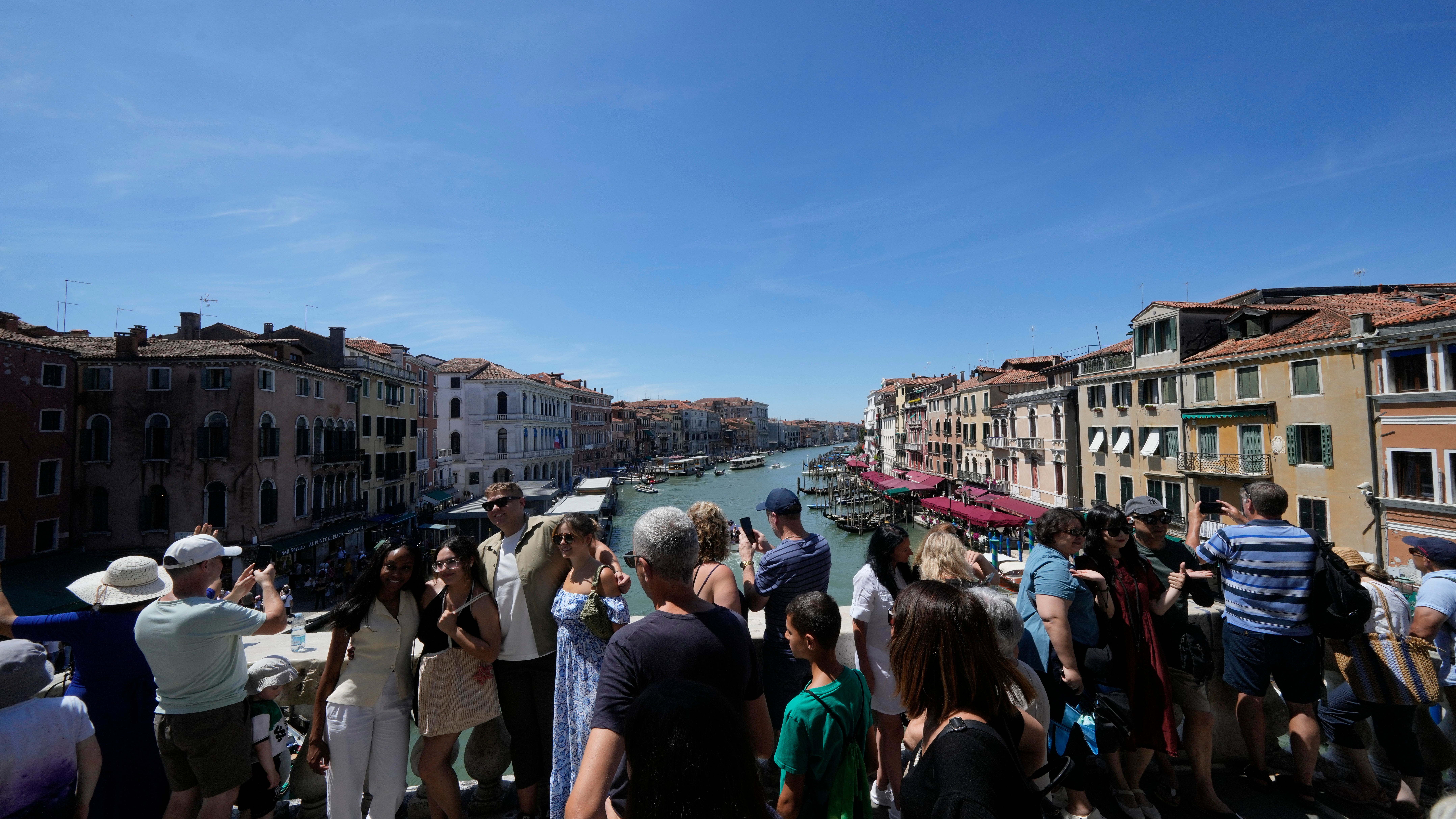 27.06.2025, Italien, Venedig: Die Rialto-Br&uuml;cke in Venedig ist von Touristen &uuml;berf&uuml;llt. (Luca Bruno/AP/dpa)
