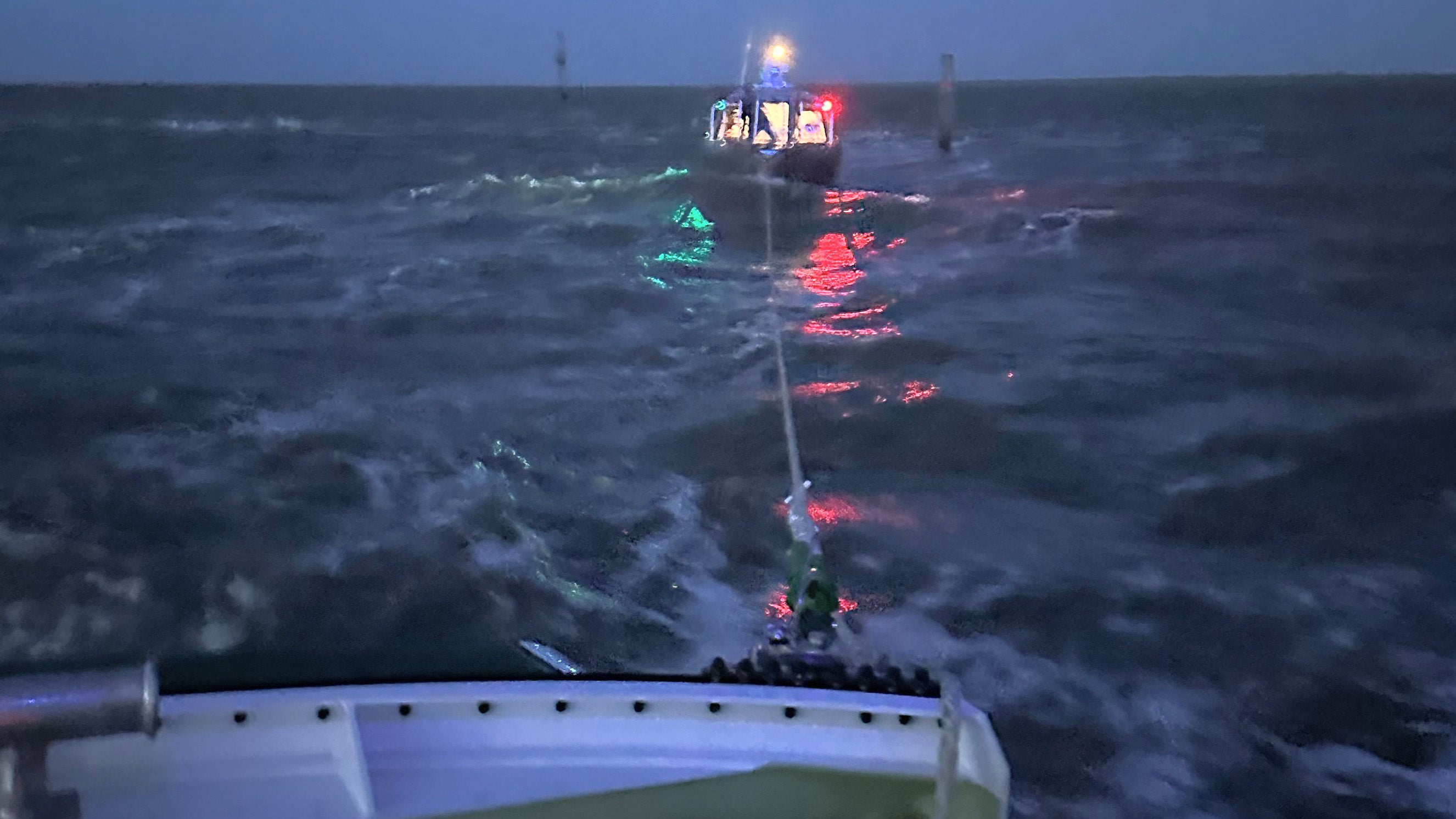 HANDOUT - 17.02.2023, Niedersachsen, Norddeich: Ein Seenotrettungsboot schleppt eine Inself&auml;hre vor Ostfriesland ab. Die etwa acht Meter lange Freizeitf&auml;hre &laquo;T&ouml;wi II&raquo; war vor Norden-Norddeich (Landkreis Aurich) bei st&uuml;rmischem Seegang auf den Leitdamm gedr&uuml;ckt worden, wie die Deutsche Gesellschaft zur Rettung Schiffbr&uuml;chiger mitteilte. Das kleine Schiff mit zw&ouml;lf Menschen an Bord hatte demnach auf dem Weg nach Juist Motorprobleme. Foto: Die Seenotretter/Deutsche Gesellschaft zur Rettung Schiffbr&uuml;chiger/dpa +++ dpa-Bildfunk +++