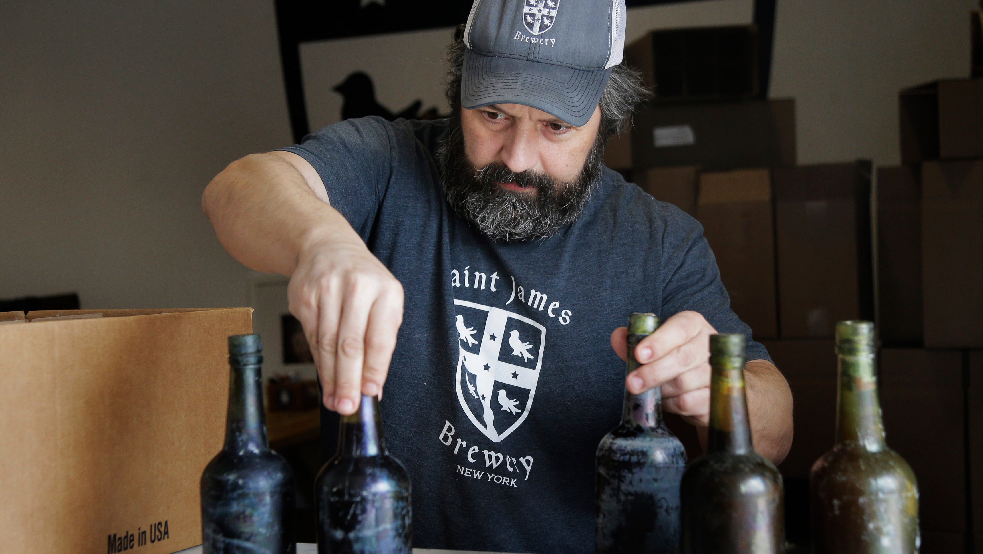 Jamie Adams zeigt einige der Bierflaschen, die aus dem Wrack der SS Oregon geborgen wurden