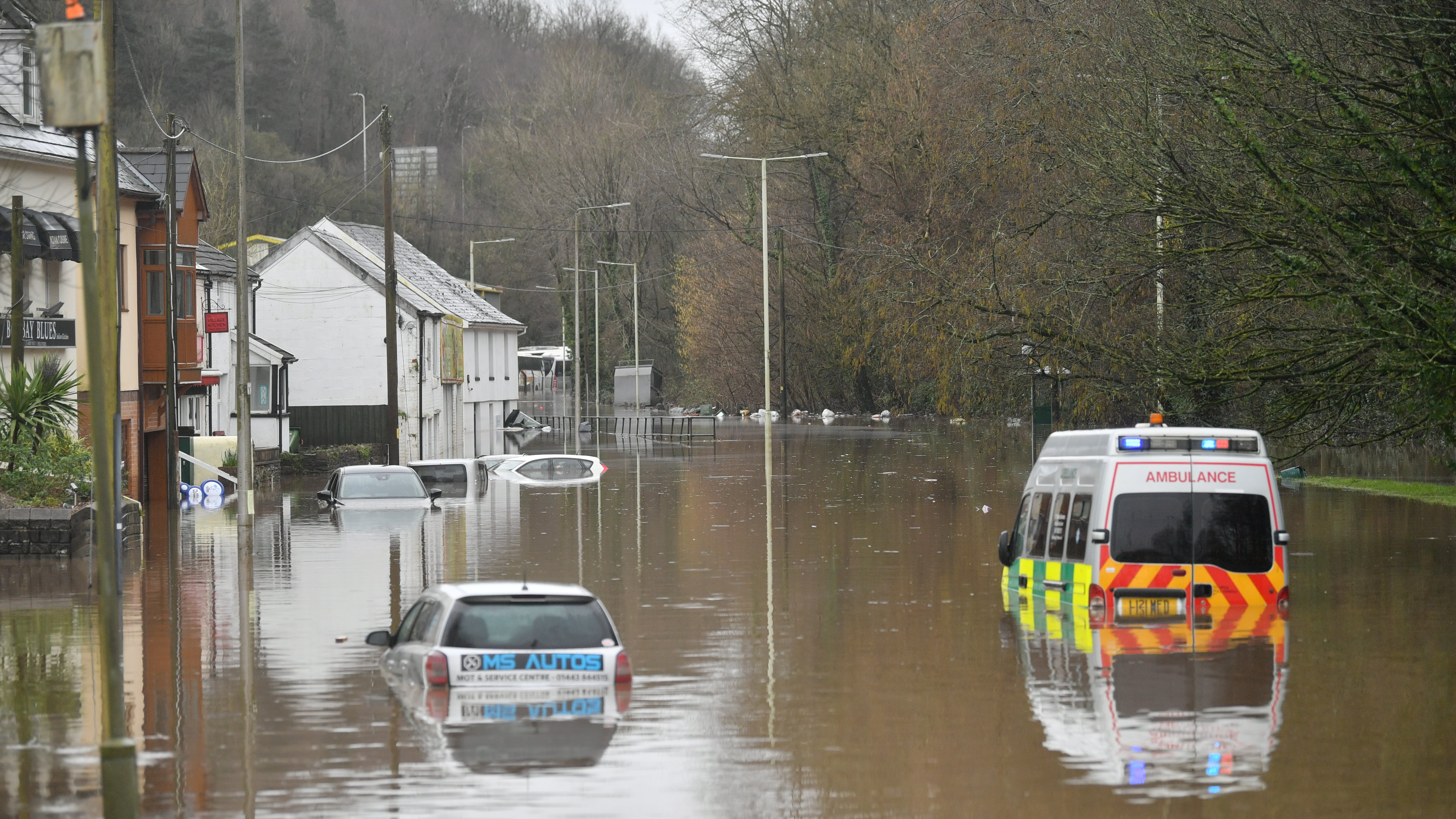 Nantgarw: Nach den &Uuml;berschwemmungen in Nantgarw, die durch den Sturm Dennis ausgel&ouml;st wurden, steht ein Krankenwagen und weitere Fahrzeuge halb eingesunken im Hochwasser.