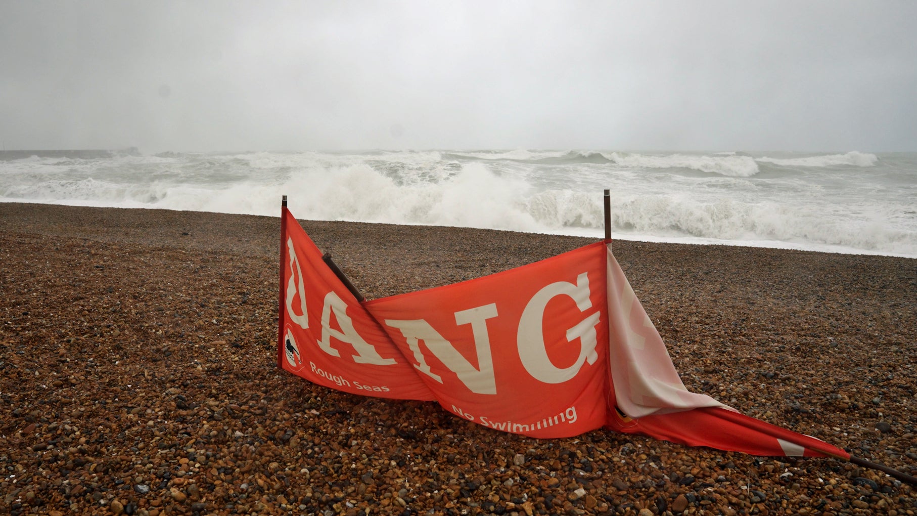 23.10.2026, Gro&szlig;britannien, Brighton: Ein Banner, das vom Schwimmen am Strand von Black Rock in Brighton, East Sussex, abr&auml;t. Gro&szlig;britannien bereitet sich auf Sturm und heftigen Regen vor, die am Freitag und am Wochenende erwartet werden (Jamie Lashmar/PA Wire/dpa)
