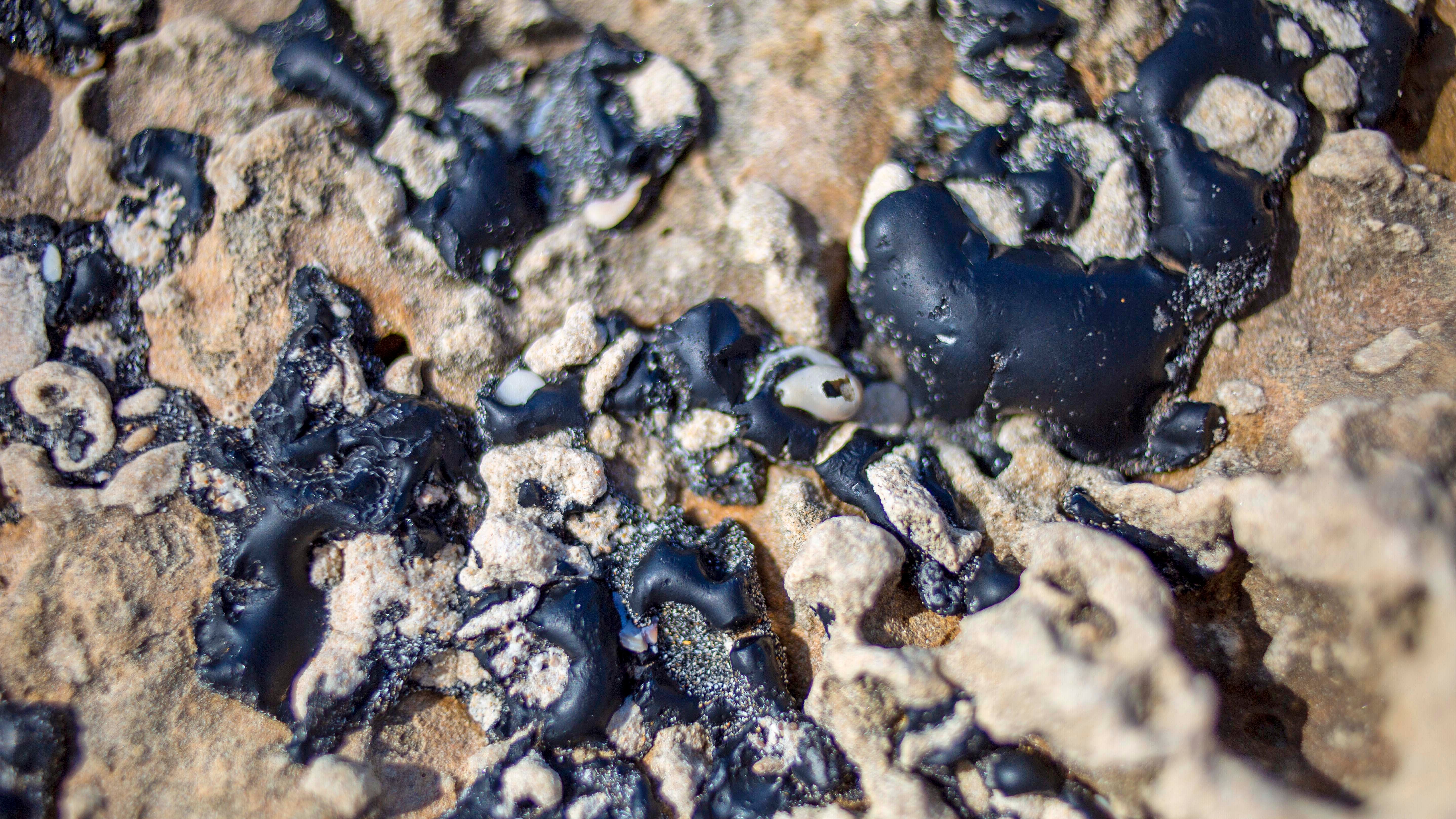 20.02.2021, Israel, Hadera: Teerst&cedil;cke kleben an einem Felsen im Mittelmeer. Nach der Verschmutzung von Str&permil;nden in Israel mit Teer hat Umweltschutzministerin Gila Gamliel rasche Aufkl&permil;rung angek&cedil;ndigt. Hunderte von Freiwilligen nehmen an einer S&permil;uberungsaktion der israelischen K&cedil;ste teil, nachdem zahlreiche Fische,&dagger;Schildkr&circ;ten und andere Meeresbewohner teerverschmiert gefunden wurden. Foto: Ariel Schalit/AP/dpa +++ dpa-Bildfunk +++