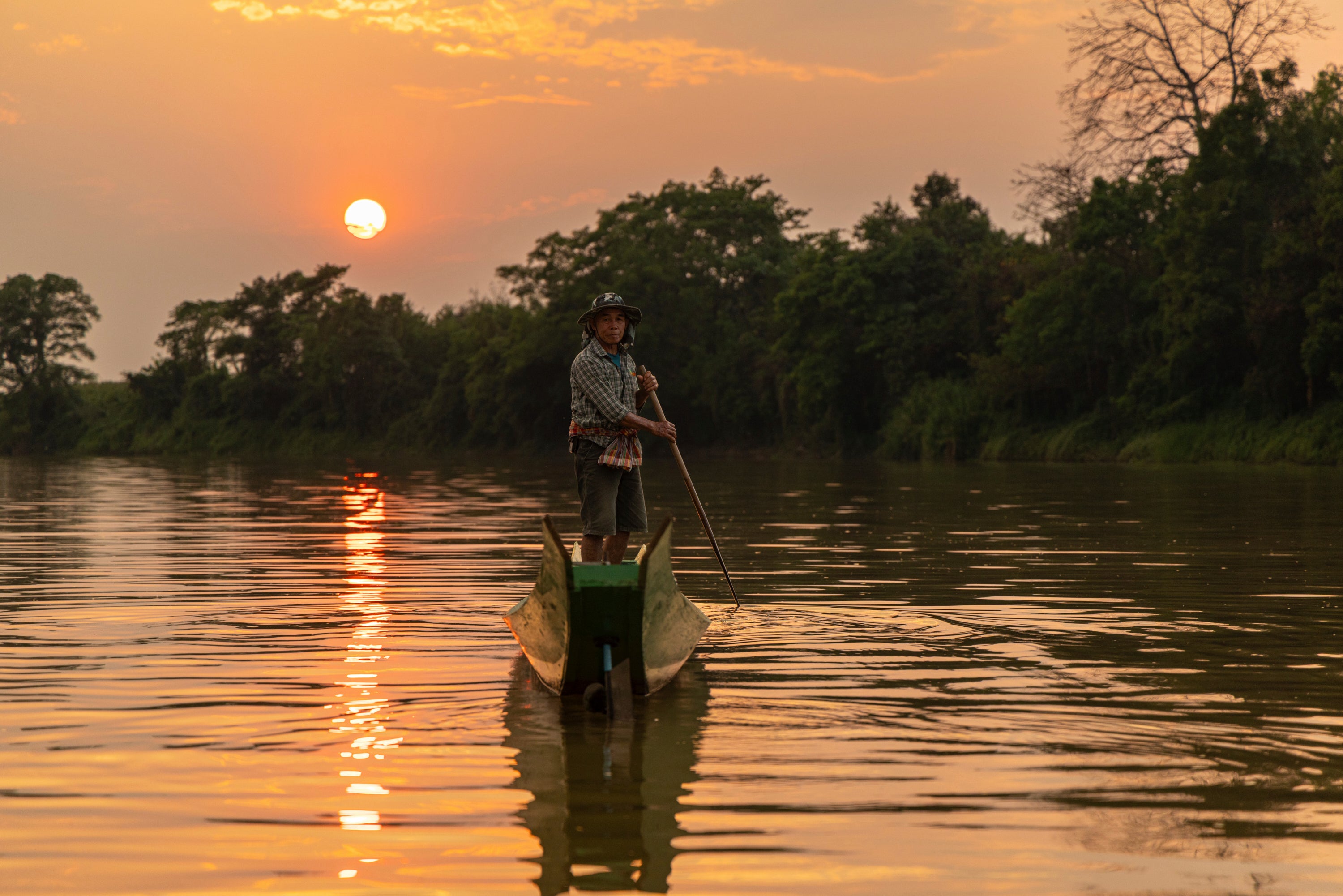 Der Fischer Sukjai Yana steuert am Samstag, dem 21. Februar 2026, in Chiang Saen, Thailand, ein Boot den Kok-Fluss hinunter. (AP Photo/Anton L. Delgado)