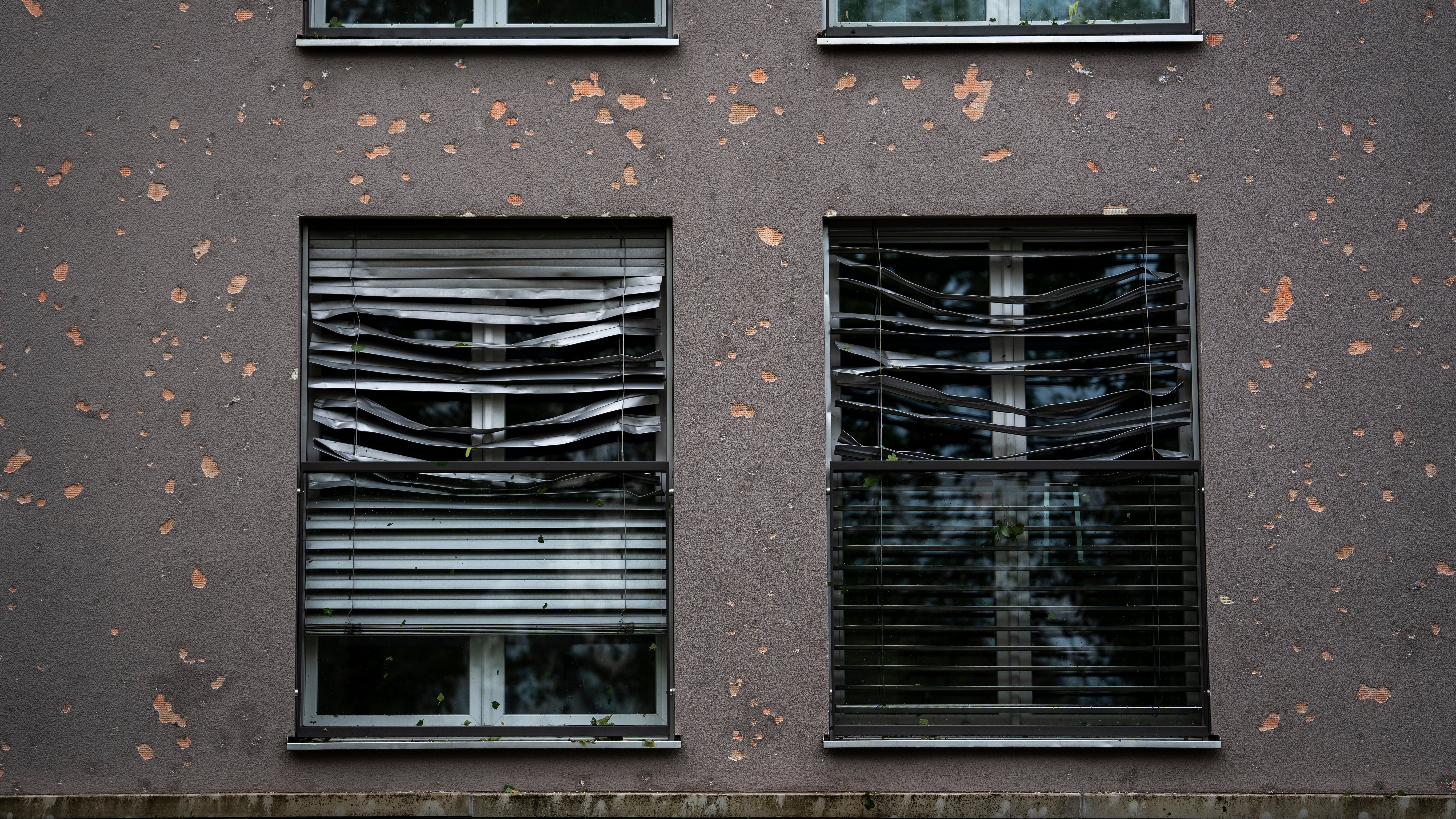 28.08.2026, Schweiz, B&uuml;lach: Blick auf eine besch&auml;digte Hausfassade und Rolll&auml;den, nach einem heftigen Unwetter mit Hagel. (Claudio Thoma/KEYSTONE/dpa)

