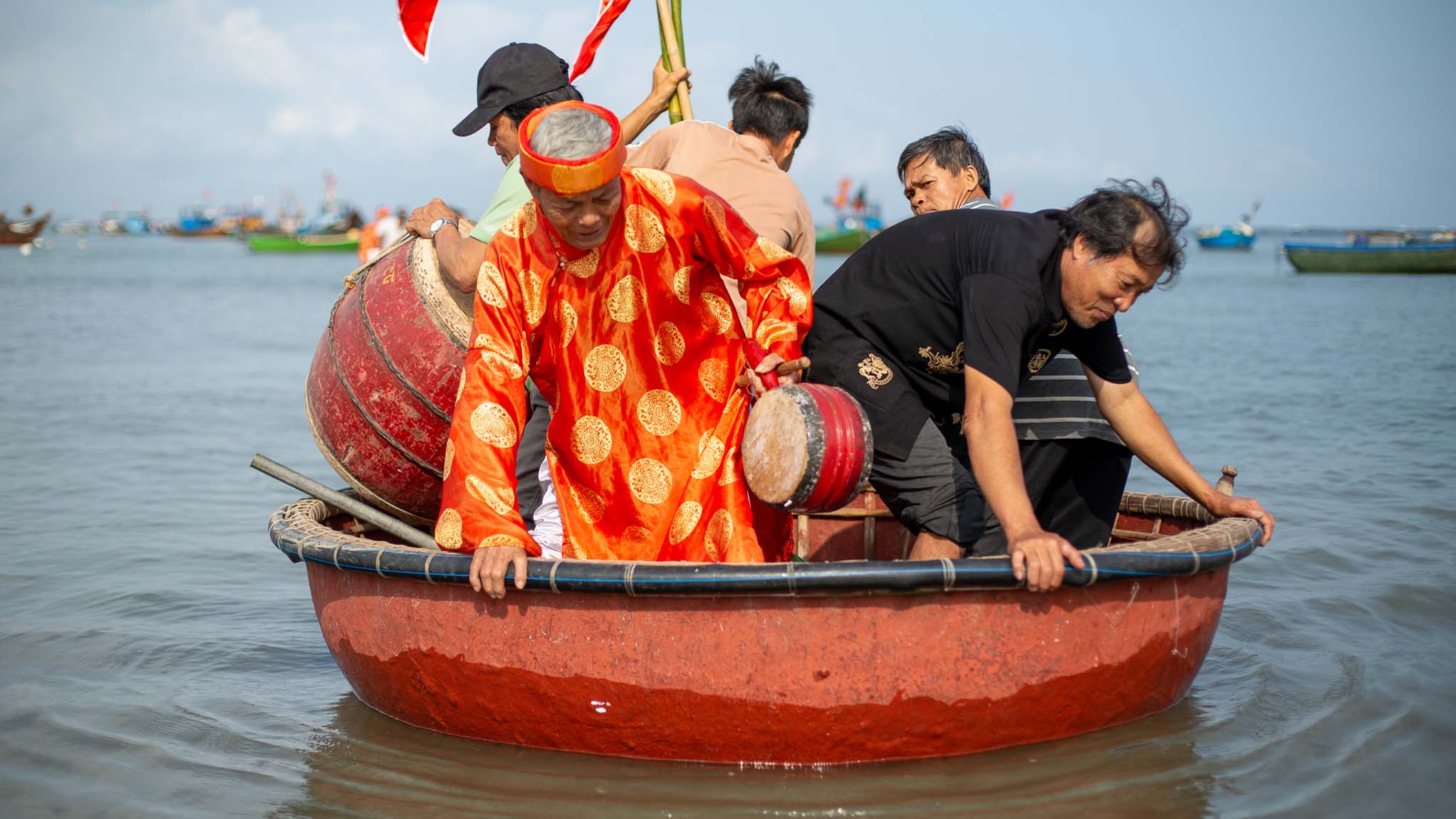 PRODUKTION - 02.03.2021, Vietnam, Tam Hai: In Tam Hai bringen einheimische Fischer w&auml;hrend des &ouml;rtlichen Walanbetungsfestes einen &auml;lteren Walanbeter in einem Kahn zu einem Tempelboot.    (zu dpa: &laquo;Schutz aus den Tiefen des Ozeans: Die Wal-G&ouml;tter von Vietnam&raquo;) Foto: Chris Humphrey/dpa +++ dpa-Bildfunk +++