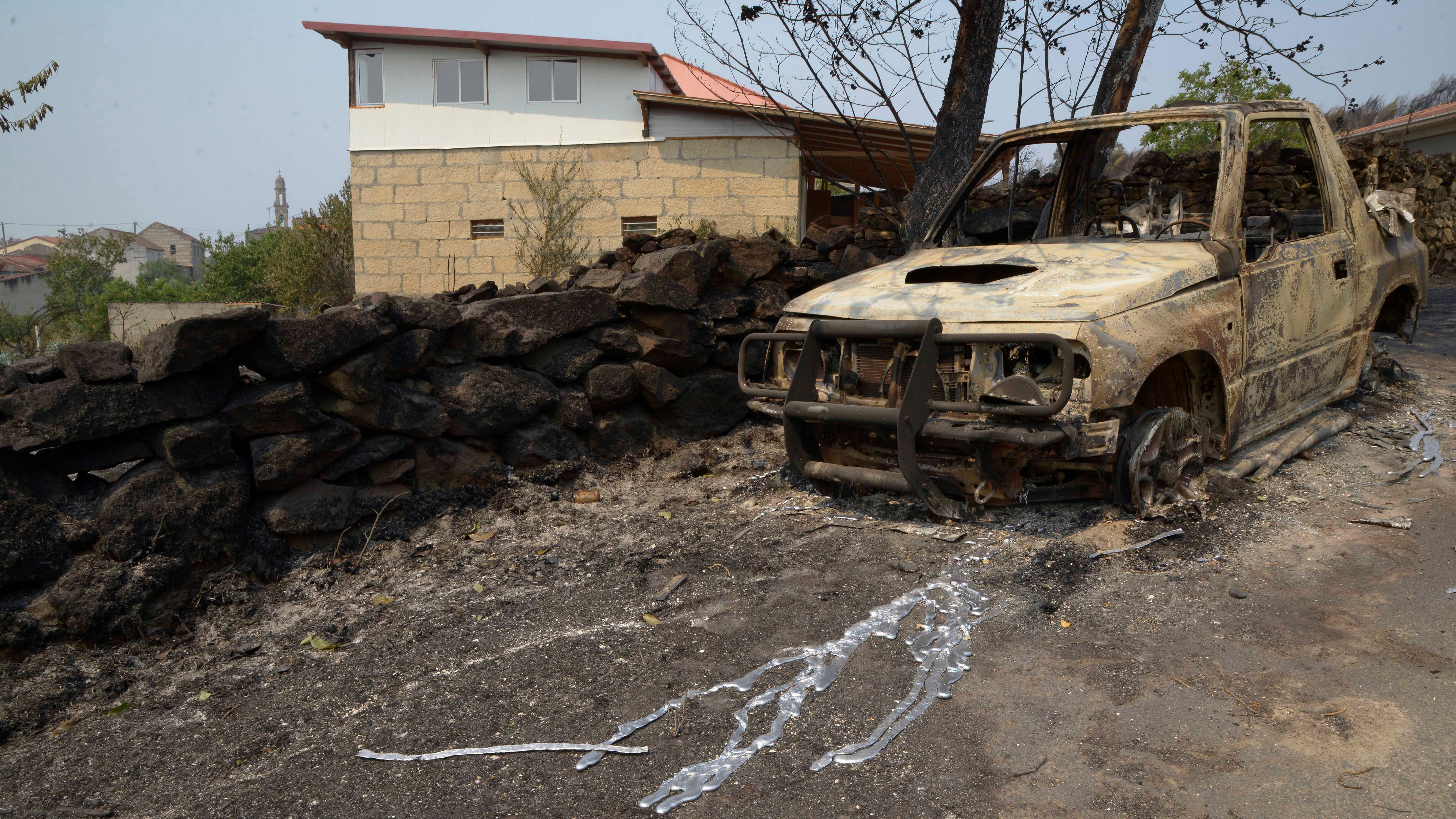 Spanien, A Caridade: Ein ausgebranntes Auto ist nach einem Waldbrand in einer Stra&szlig;e in A Caridade zu sehen. Foto: Rosa Veiga/EUROPA PRESS/dpa