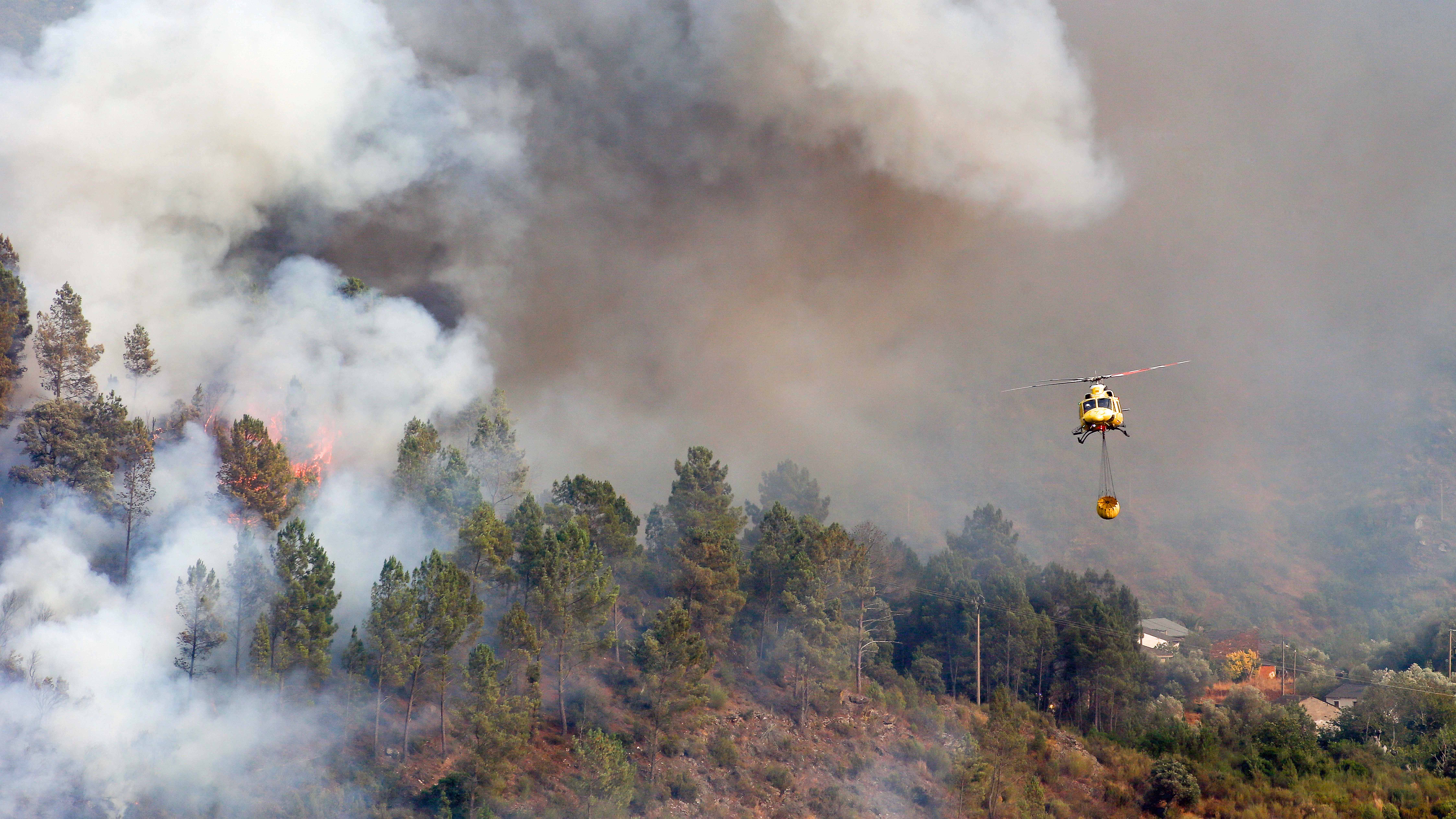 : Ein Hubschrauber transportiert Wasser zum L&ouml;schen des Feuers in Quiroga. Foto: Carlos Castro/EUROPA PRESS/dpa