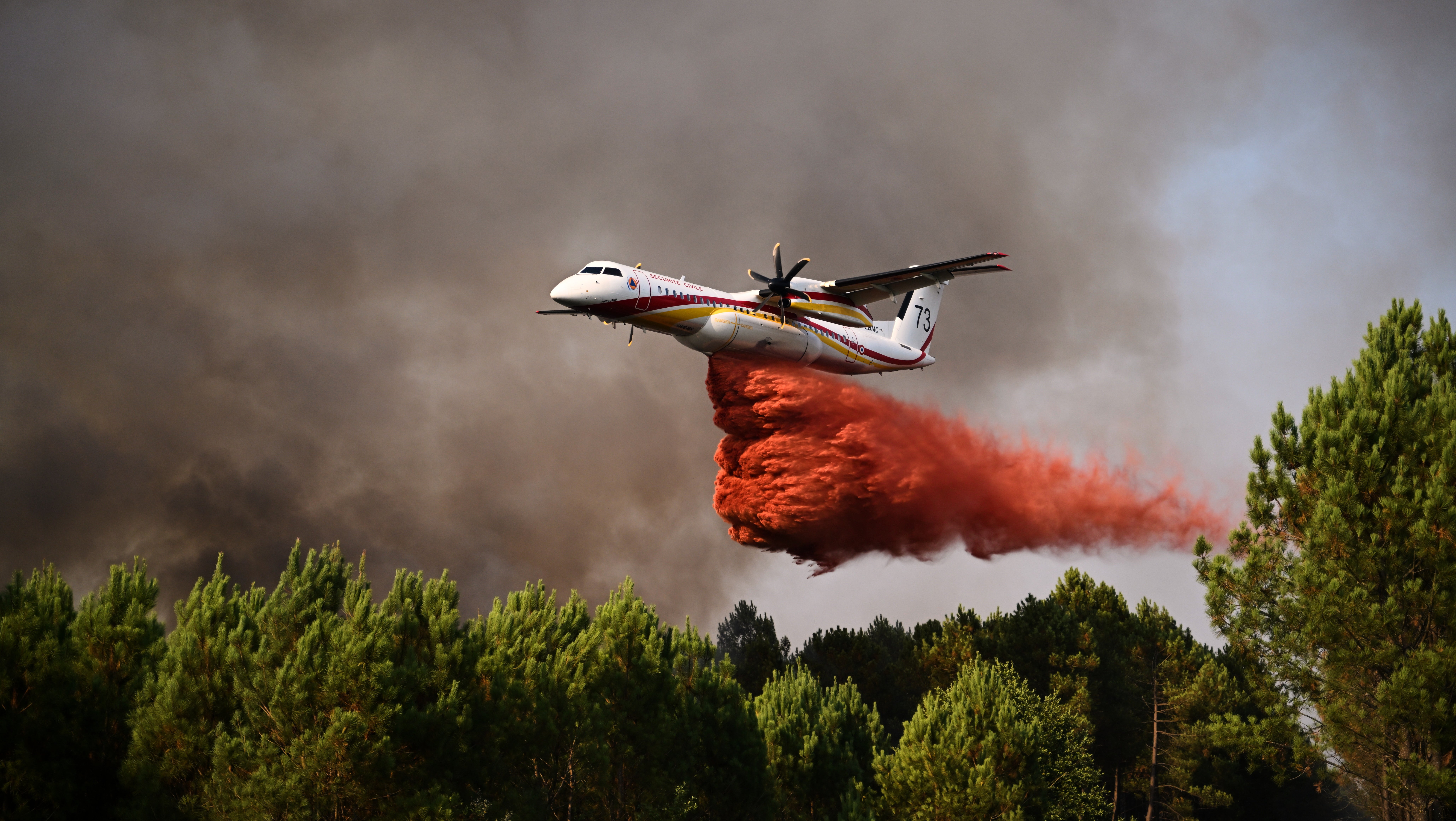 29.07.2026, Frankreich, Blagon: Eine De Havilland Canada Dash 8-400 verspr&uuml;ht L&ouml;schmittel, w&auml;hrend sie bei den Waldbr&auml;nden im S&uuml;dwesten Frankreichs &uuml;ber einen Wald fliegt. (Emma Da Silva/AP/dpa)