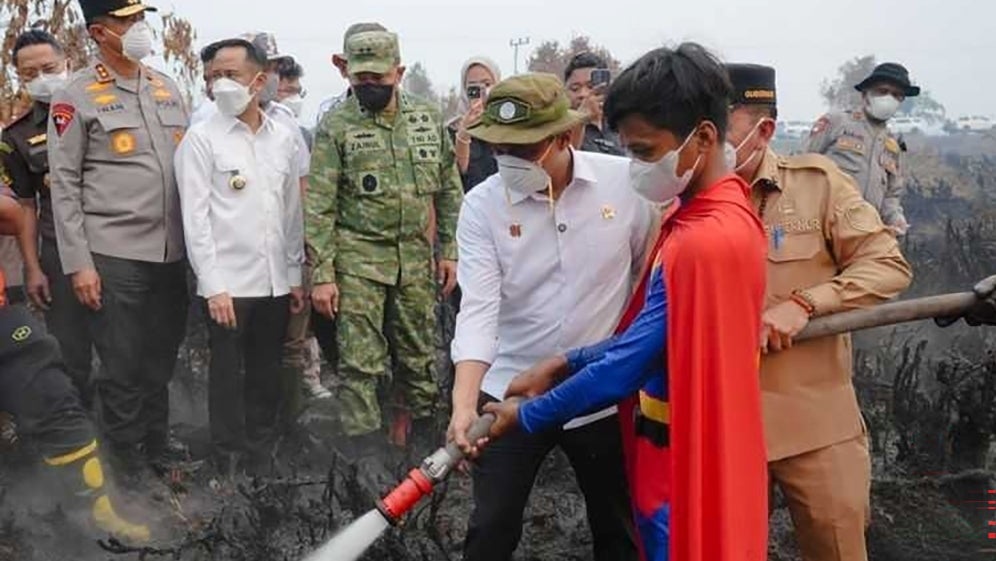 ACHTUNG: Nur zur redaktionellen Verwendung und nur mit vollst&auml;ndiger Nennung des vollst&auml;ndigen Credits

19.08.2026, Indonesien, Kalimantan: Die vom Forestry Ministry Indonesia zur Verf&uuml;gung gestellte Aufnahme zeigt einen 17-J&auml;hrigen im Superman-Kost&uuml;m, w&auml;hrend er den Einsatzkr&auml;ften auf Borneo beim L&ouml;schen schwerer Waldbr&auml;nde hilft (bestm&ouml;gliche Qualit&auml;t). Videos mit dem Jugendlichen bei der Arbeit gehen derzeit in sozialen Netzwerken viral. (Forestry Ministry Indonesia/dpa)
