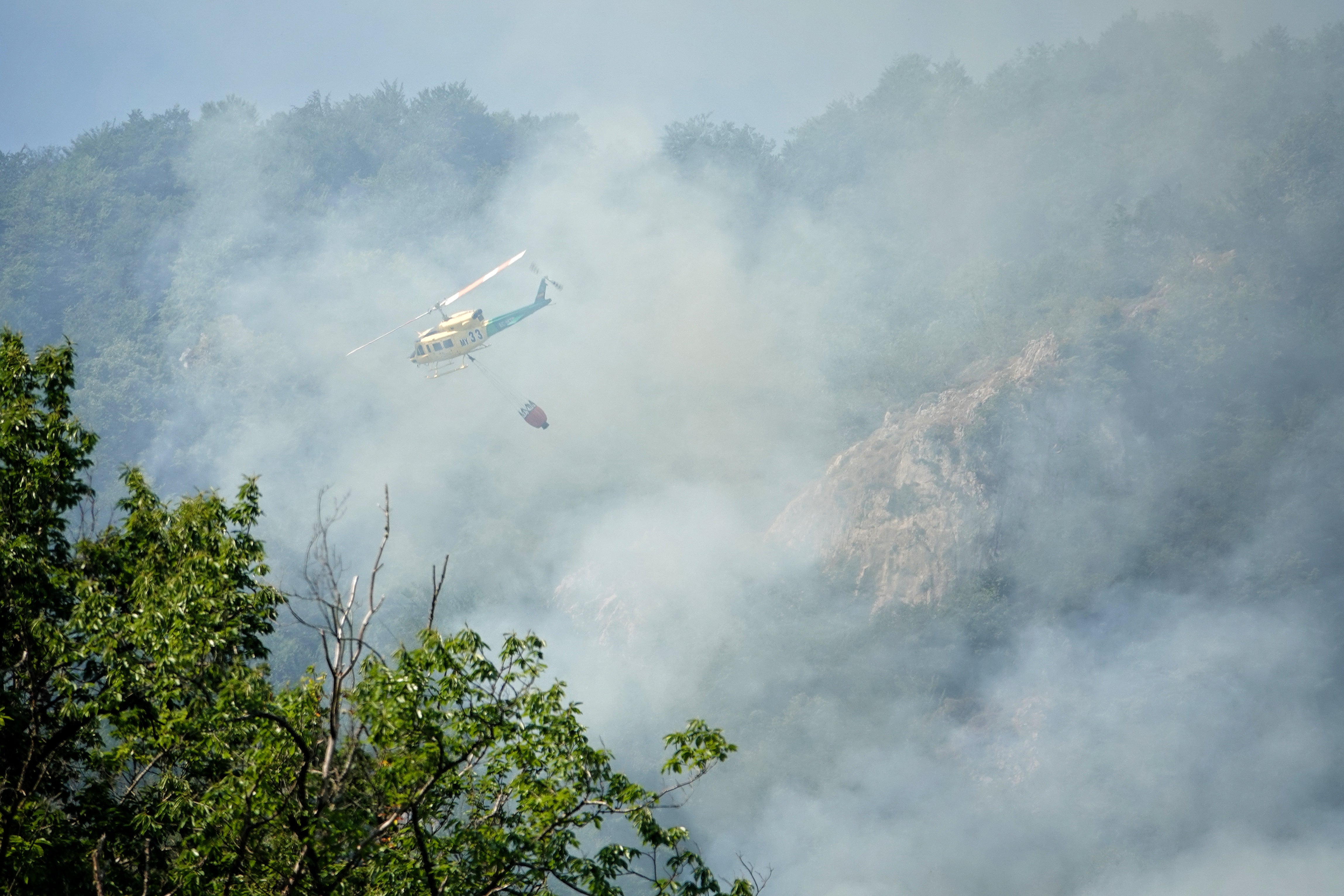 06.07.2026, Spanien, Ribota de Sajambre: Ein Hubschrauber unterst&uuml;tzt L&ouml;scharbeiten bei einem Waldbrand. (Xuan Cueto/EUROPA PRESS/dpa)

