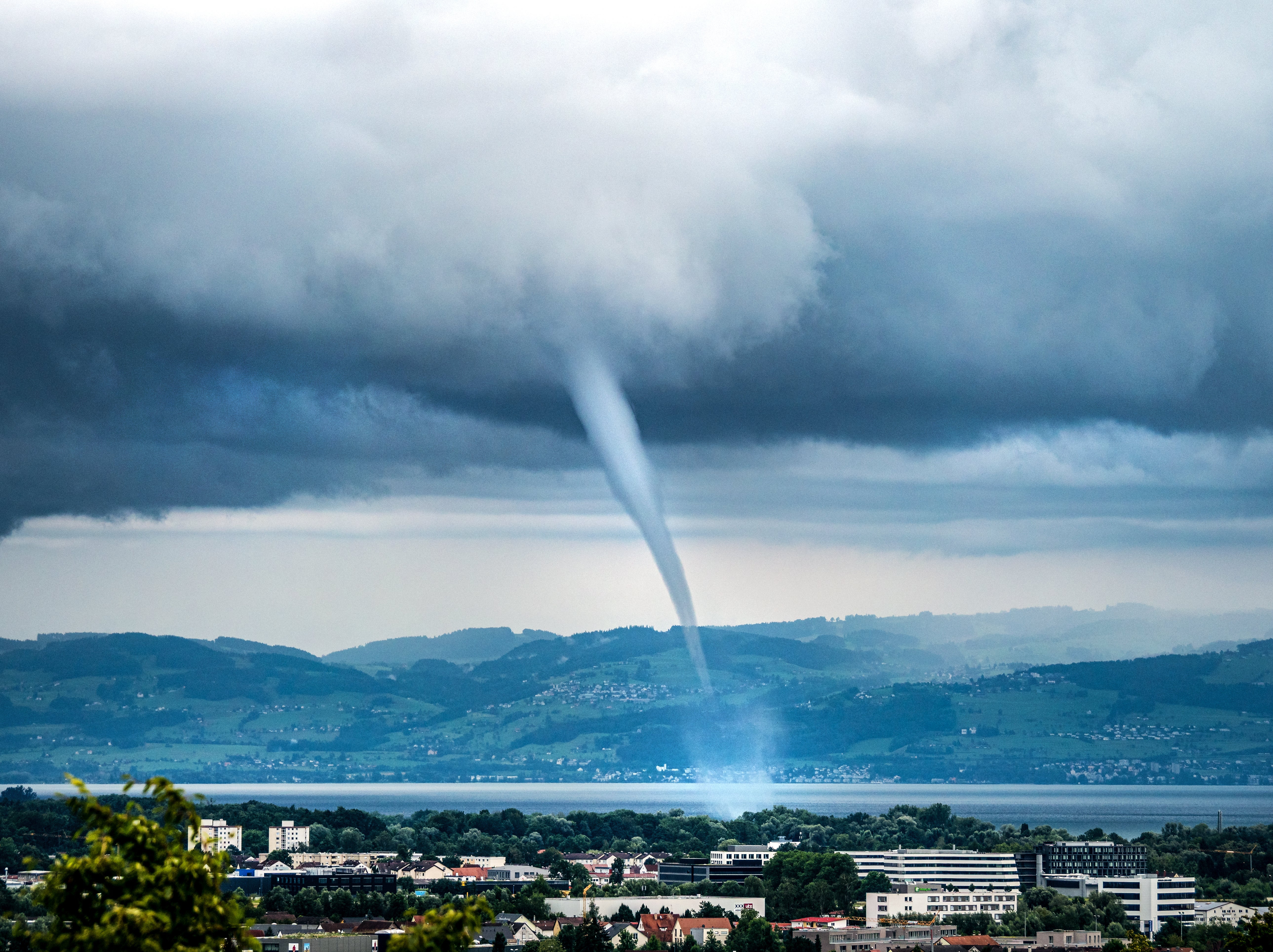 01.08.2021, Baden-W&uuml;rttemberg, Friedrichshafen: Eine Wasserhose fegt vor Friedrichshafen &uuml;ber den Bodensee. Solche Wasserhosen bilden sich &uuml;ber deutschen Seen zwar immer wieder, durch den Klimawandel k&ouml;nnten sie aber st&auml;rker werden. (Dr. Christoph Sommergruber/dpa)