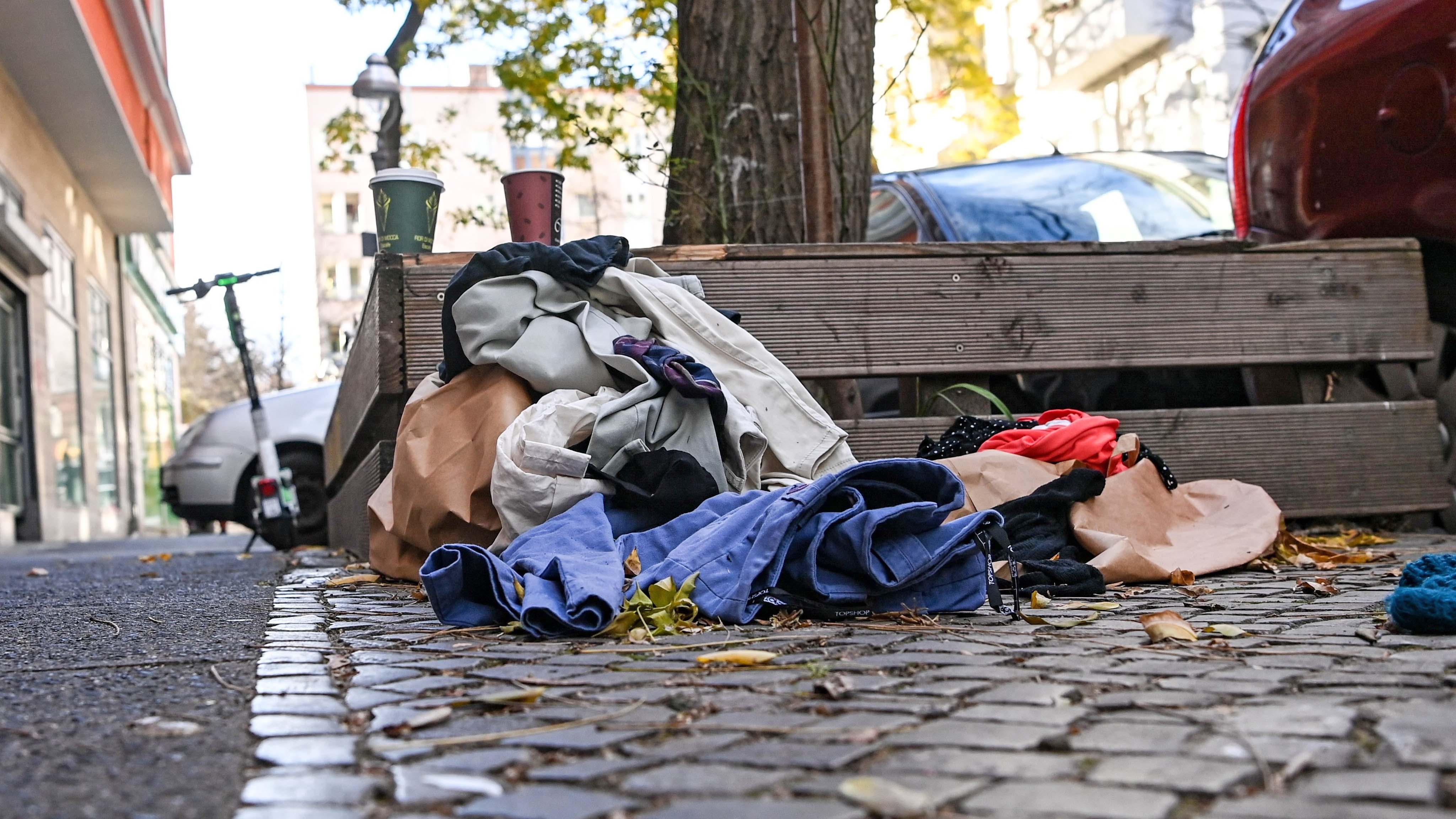 ARCHIV - 23.11.2020, Berlin: Weggeworfene Kleidung liegt in Neuk&ouml;lln auf dem Gehweg am Stra&szlig;enrand. Jedes Jahr werden sch&auml;tzungsweise 50 Milliarden Tonnen Textilien produziert. Dreiviertel davon d&uuml;rfte auf M&uuml;lldeponien landen. (zu dpa &laquo;Klamotten recyceln: Das verflixte Kreislaufproblem bei Textilien&raquo;) Foto: Jens Kalaene/dpa-Zentralbild/dpa +++ dpa-Bildfunk +++