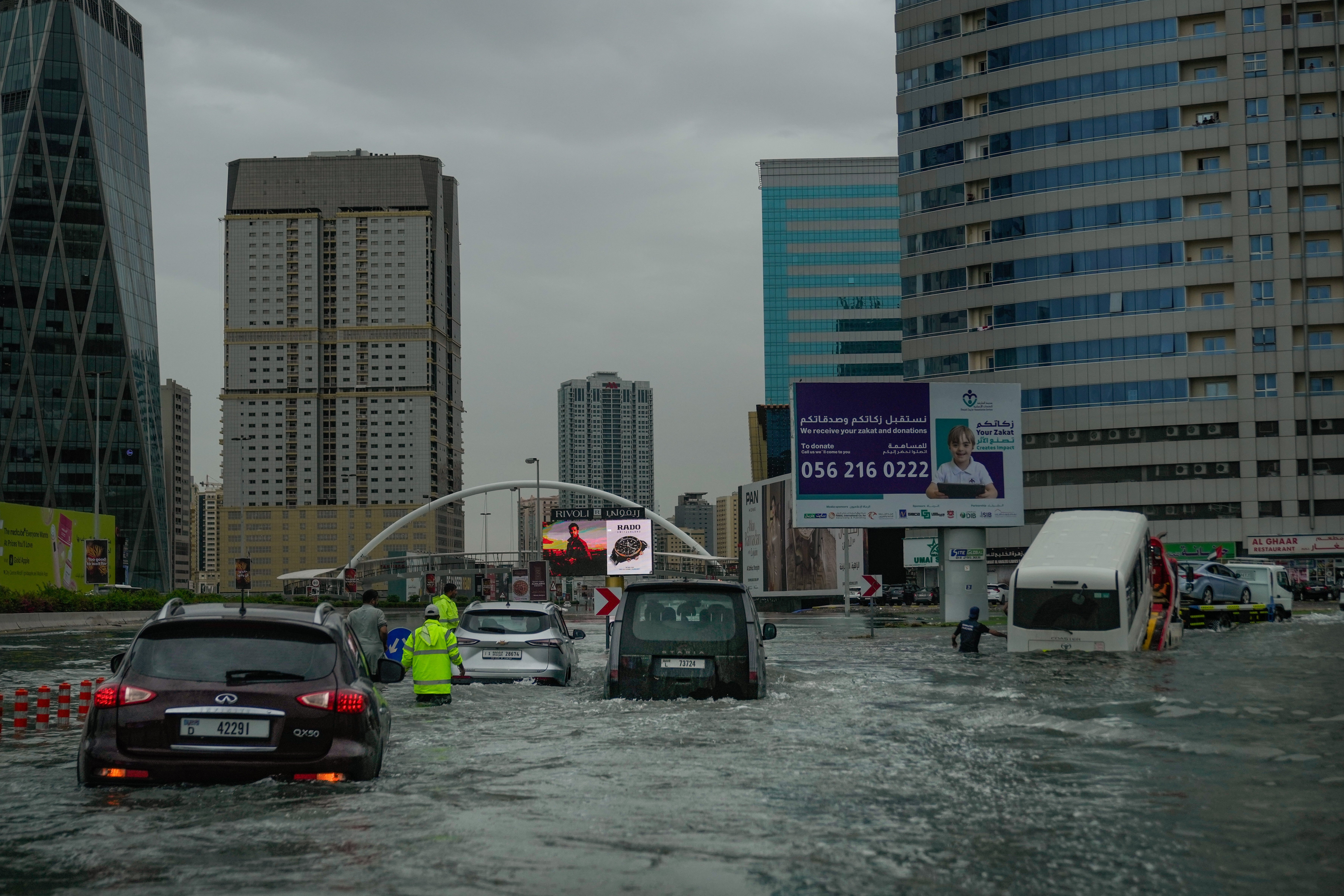 27.03.2026, Vereinigte Arabische Emirate, Dubai: Fahrzeuge stecken nach heftigen Regenf&auml;llen auf einer &uuml;berfluteten Stra&szlig;e fest, w&auml;hrend ein Lieferwagen abgeschleppt wird. (Uncredited/AP/dpa)