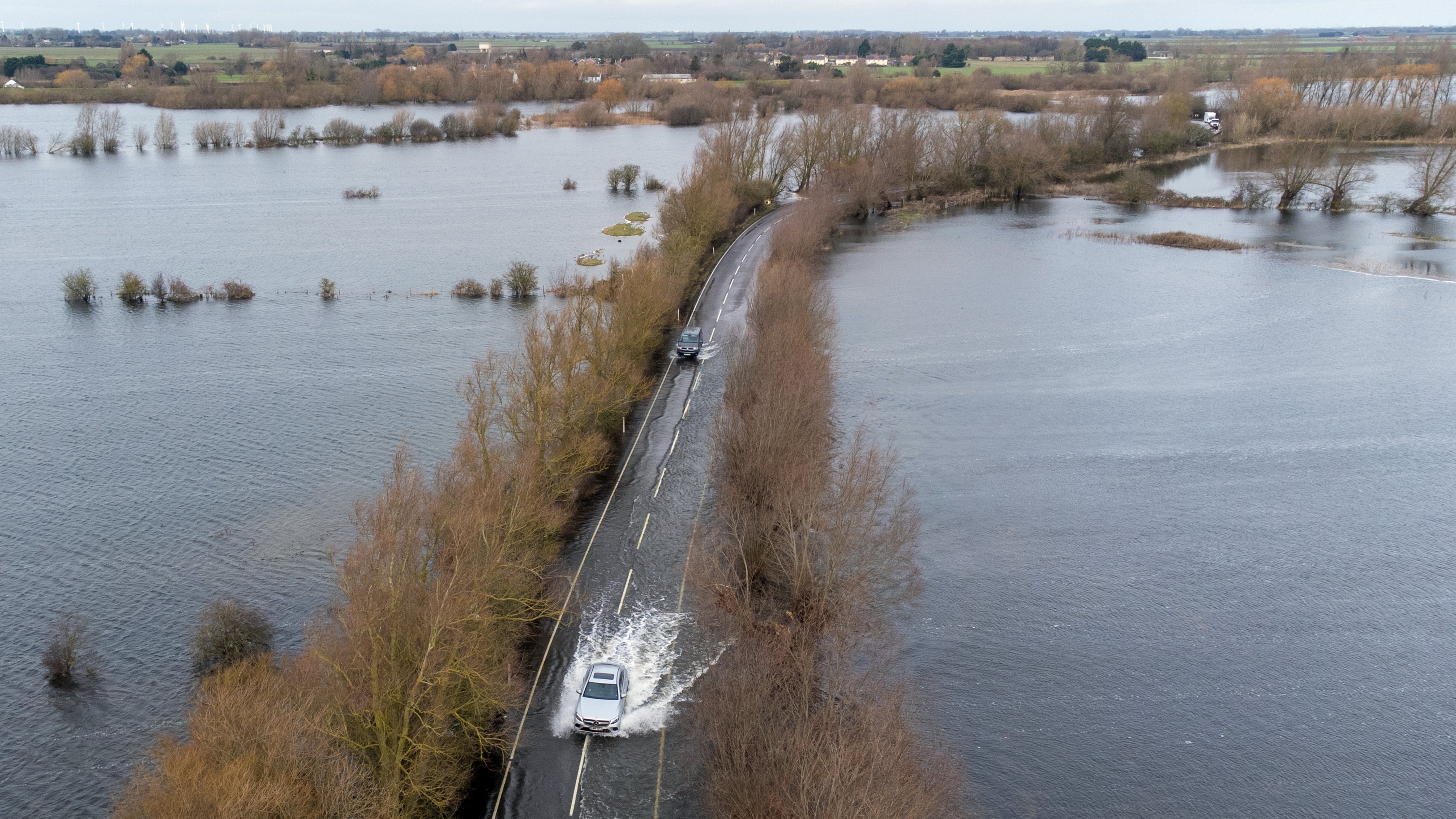 Gro&szlig;britannien, Welney: Autos fahren die &uuml;berflutete Stra&szlig;e A101 entlang. 
